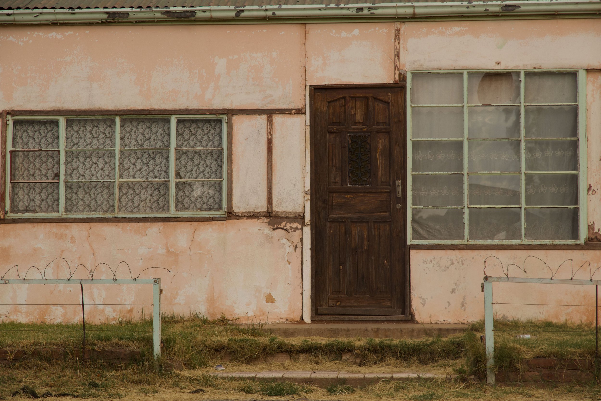 Neglected building with peeling walls and barbed wire, showing unsafe property conditions in a premises liability case