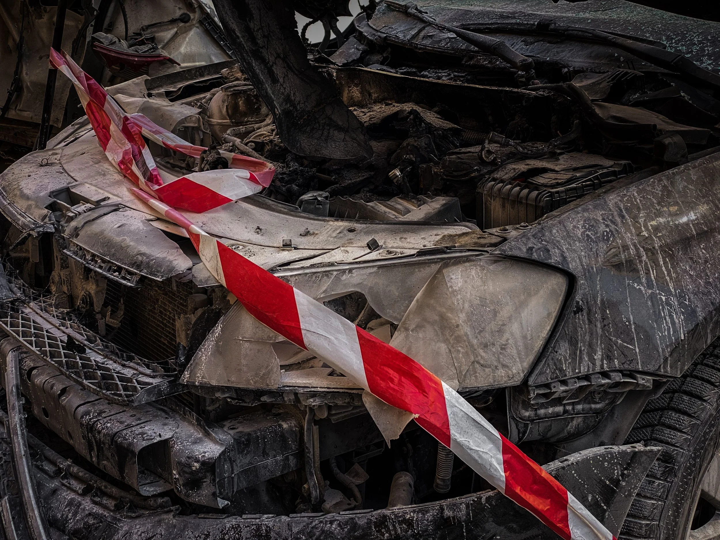 Damaged car wrapped in police caution tape representing auto collision and personal injury legal claims in New Jersey