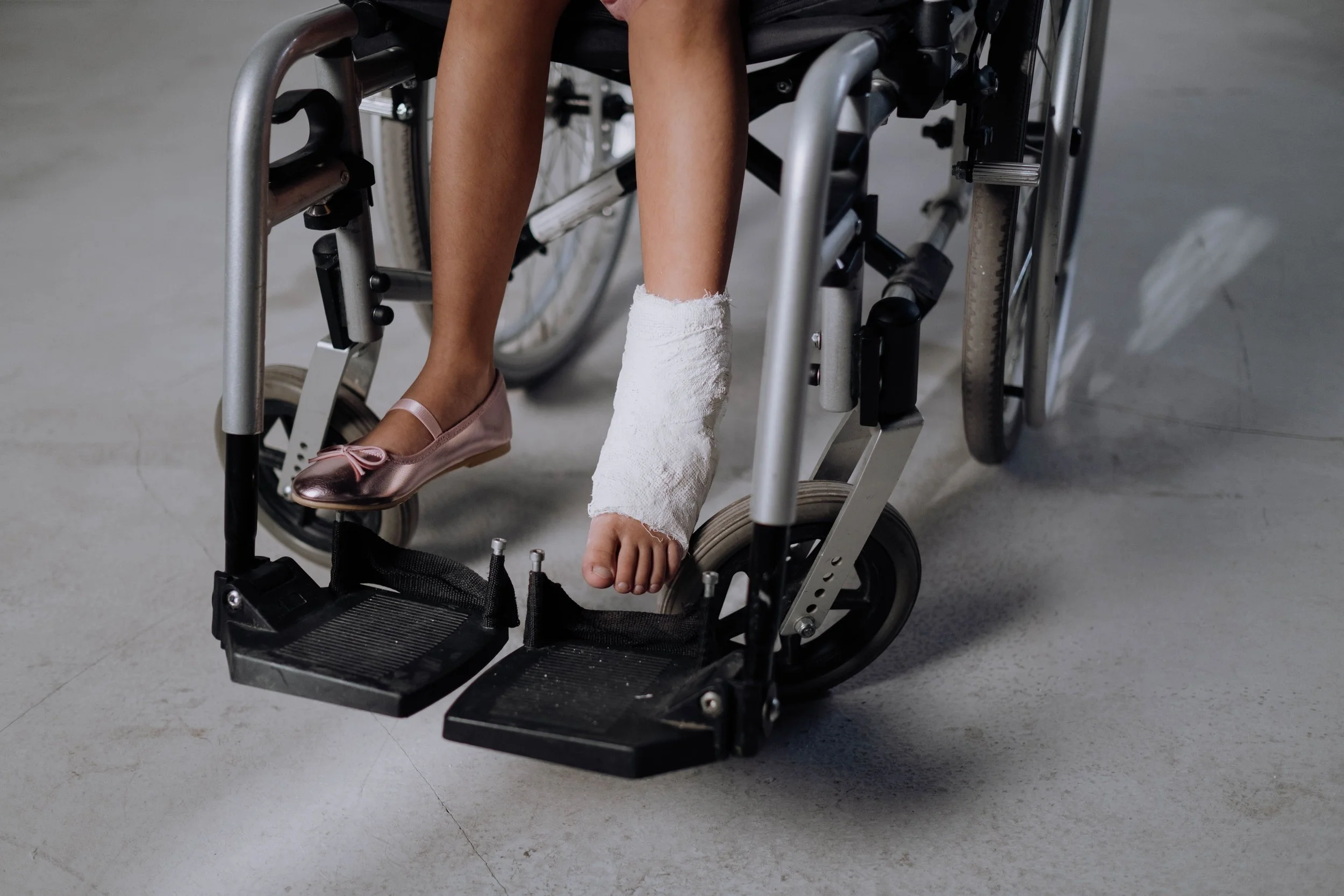 Person in a wheelchair with a bandaged foot, representing catastrophic injury and long-term disability