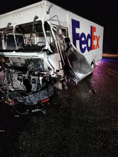 Severely damaged FedEx delivery truck involved in a nighttime accident showing vehicle collision evidence