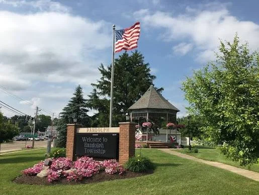Cartel de «Bienvenidos al municipio de Randolph», con un mirador y flores, donde el bufete Barreto Law Firm ofrece representación legal en casos de lesiones personales en Nueva Jersey