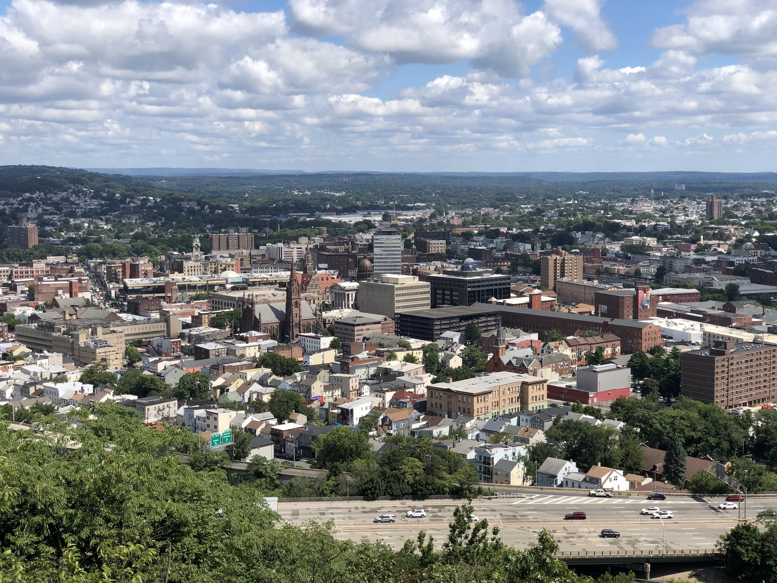 Aerial view of Paterson, New Jersey city skyline and highway, where a local personal injury lawyer prepares your case