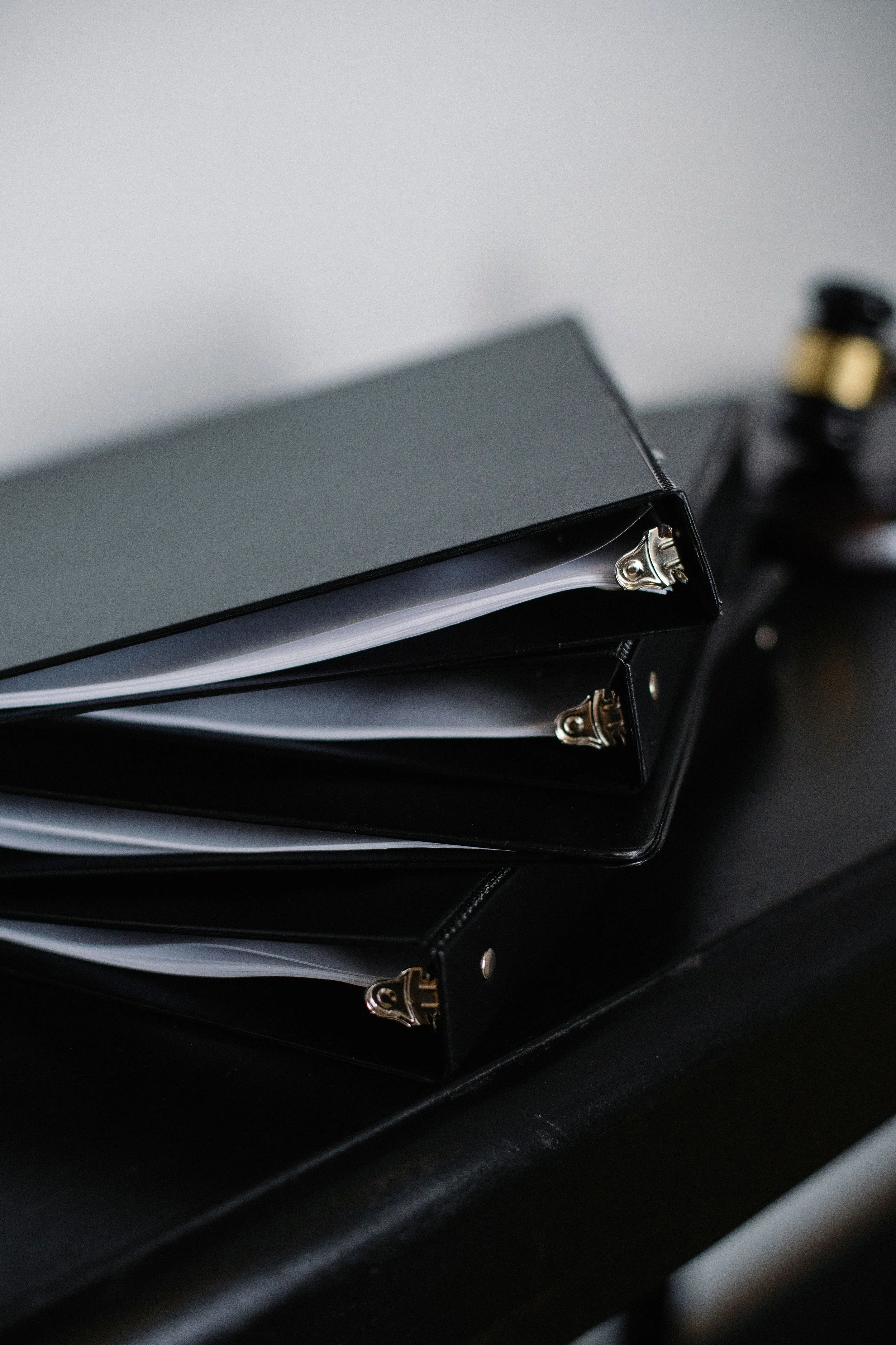 Stack of black binders with metal rings, representing case files for a catastrophic injury claim