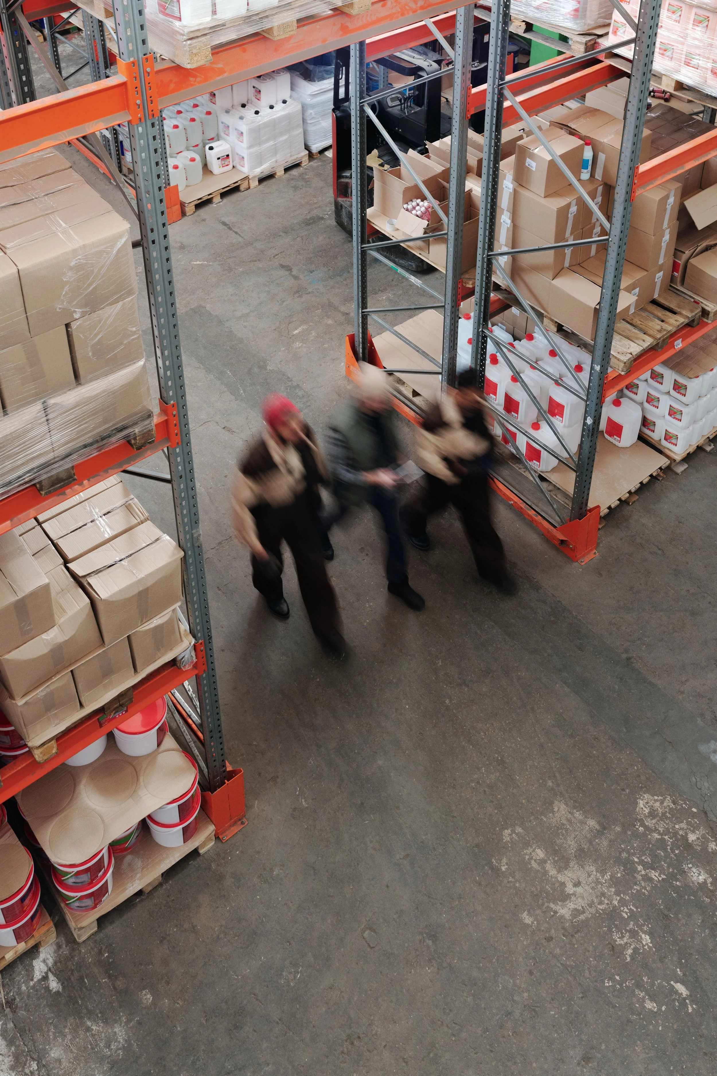 Warehouse workers beside stacked pallets, where defective product liability injuries can happen