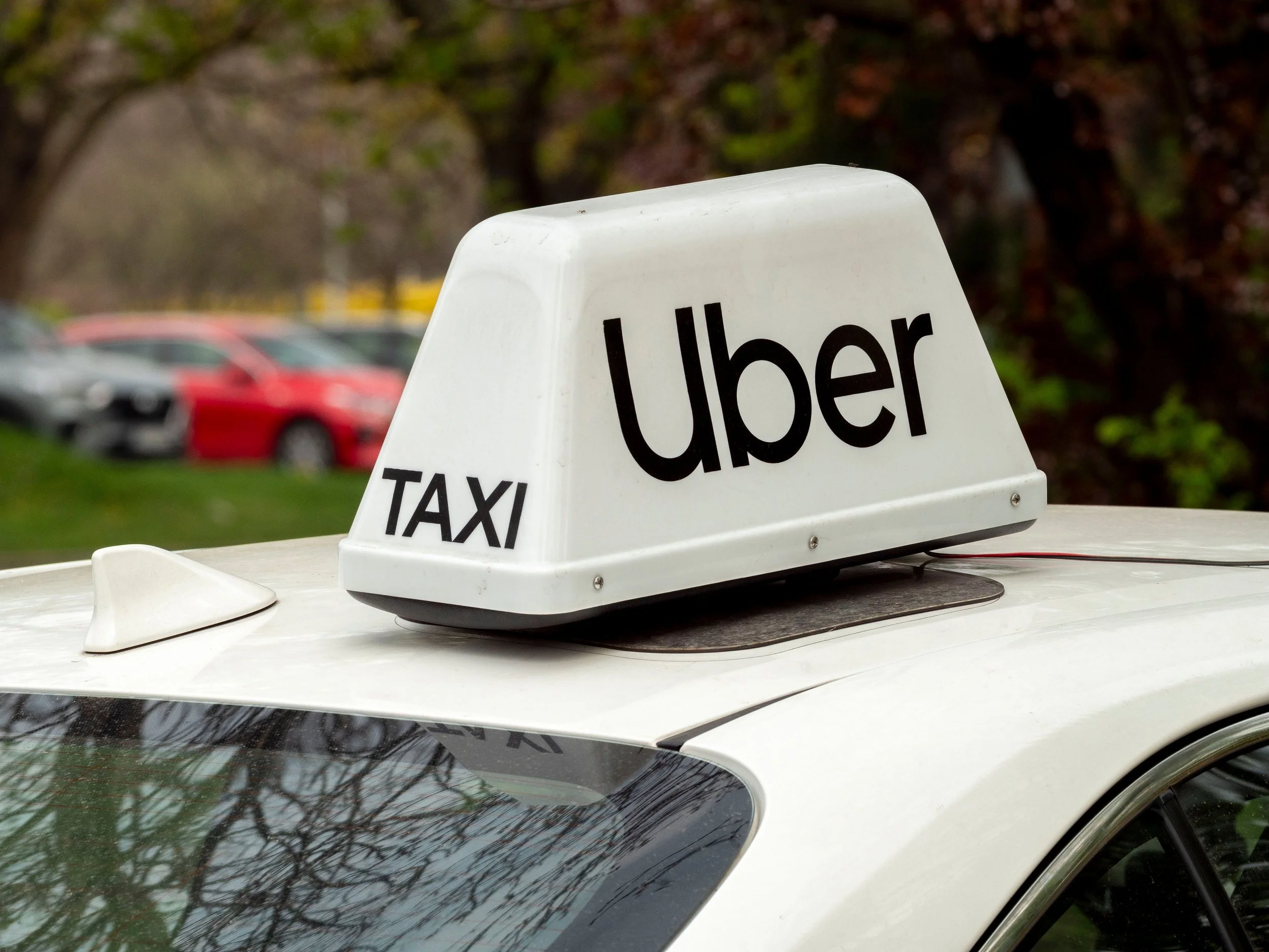 Uber taxi sign on the roof of a white car, representing rideshare driver accident claims