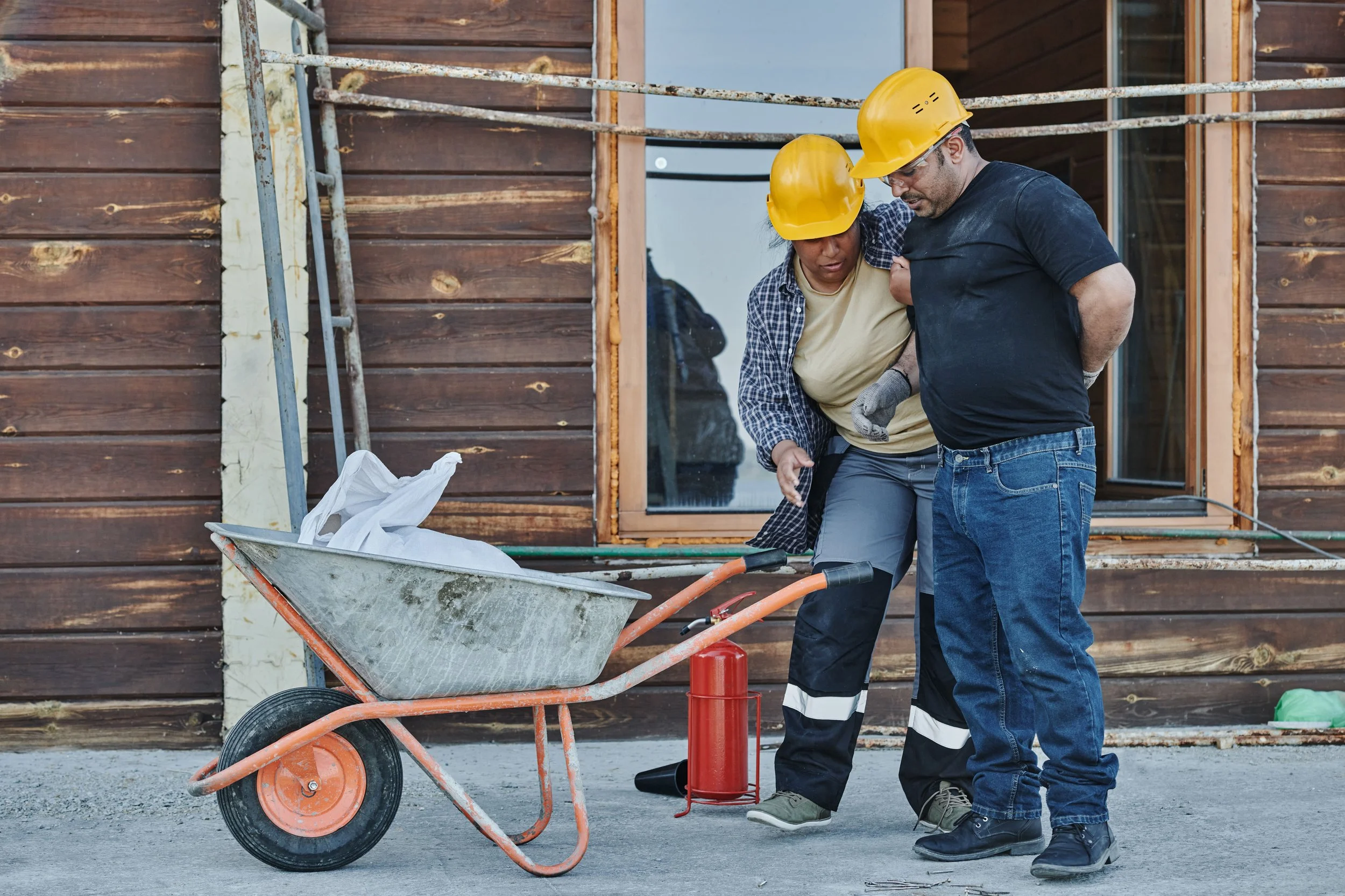Construction worker supporting an injured coworker after a construction accident at a building site