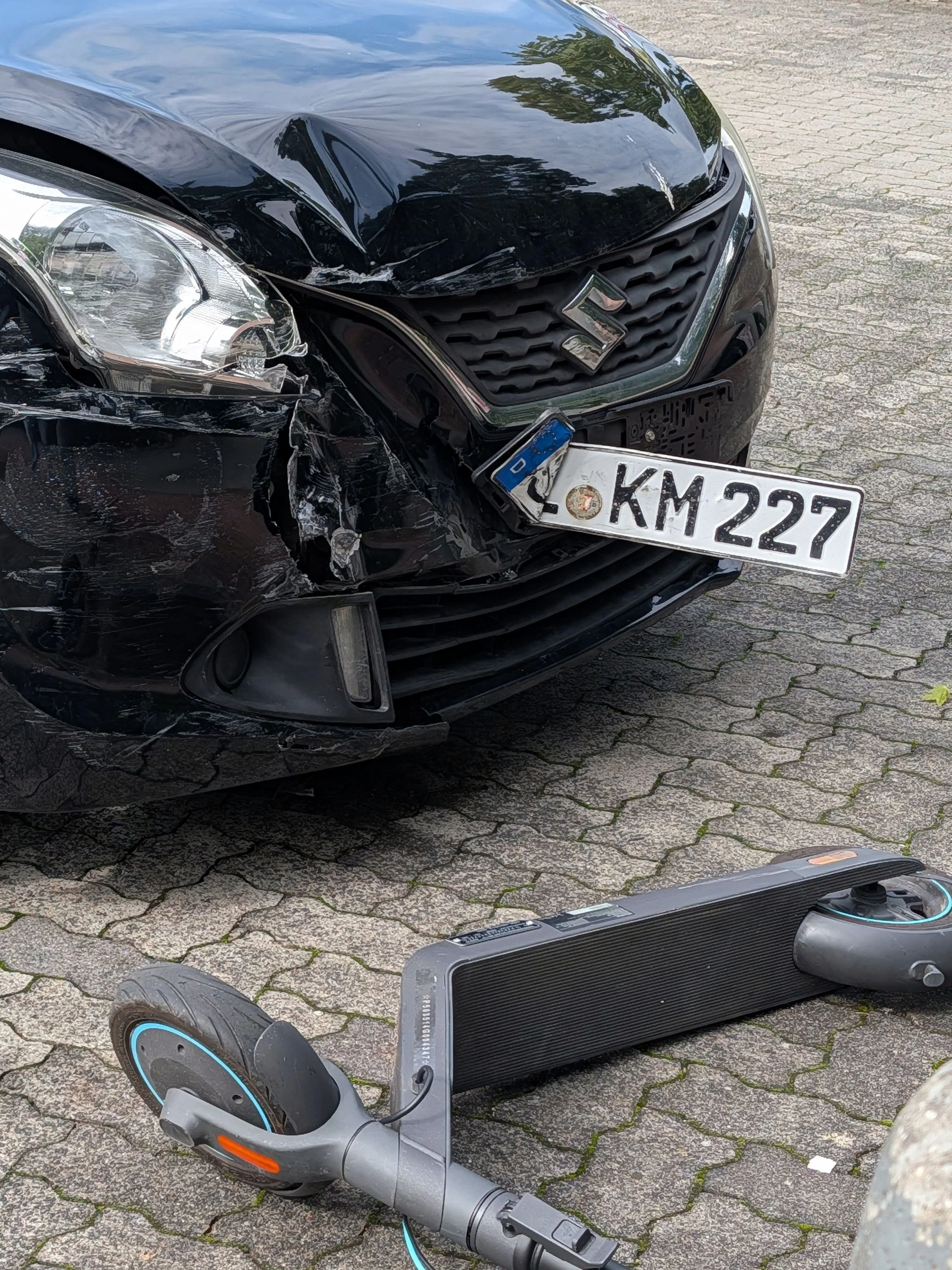 Car with crushed front end and broken headlight after a collision, showing damage from a car accident