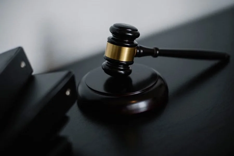 Black gavel on a sound block beside binders, a law firm that fights the legal battle so injury clients can focus on healing