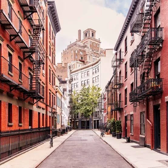 Narrow city street lined with brick buildings, a crowded urban area like West New York where injury claims can arise