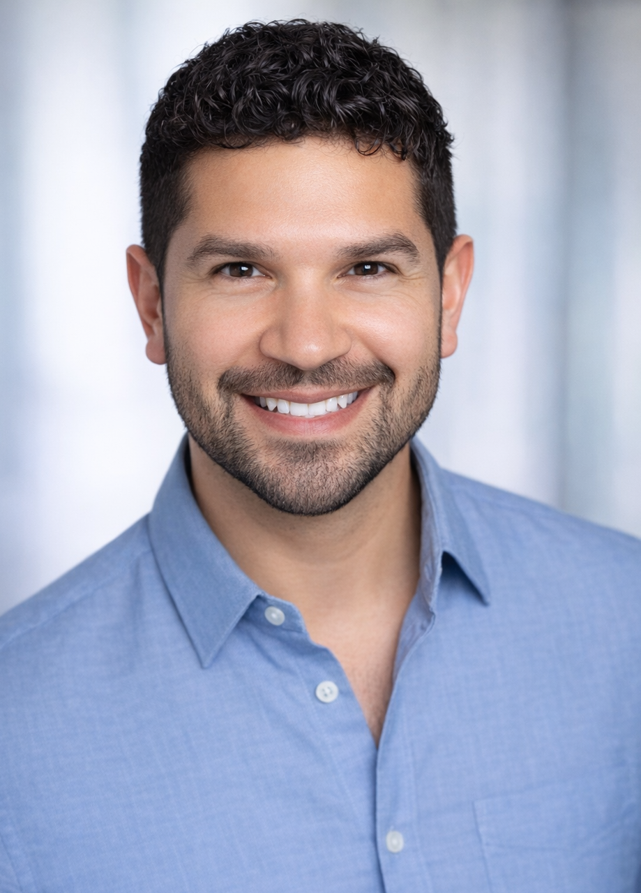 White hispanic male in blue shirt smiling