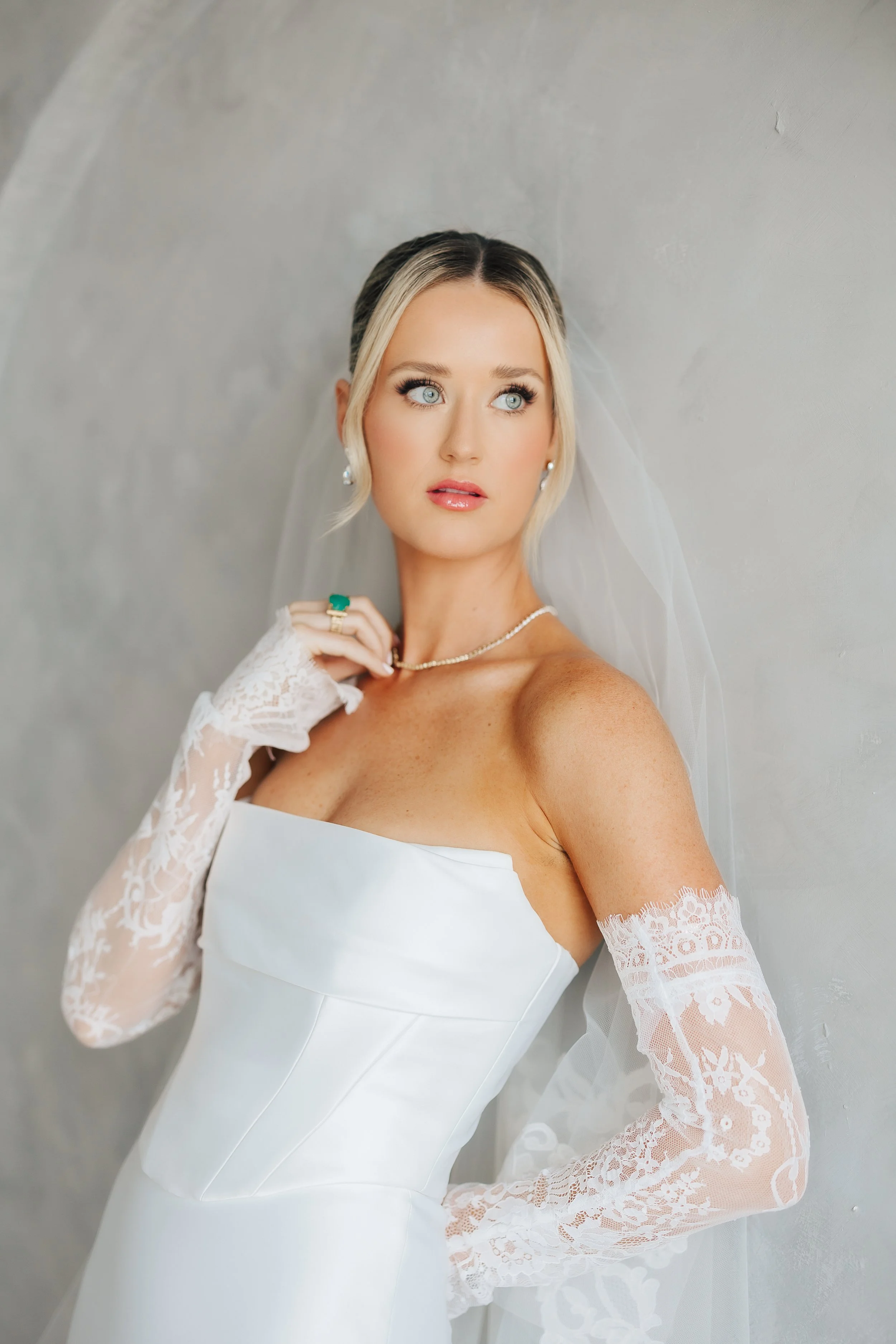 Soft glam wedding makeup with lashes and a chic slick updo