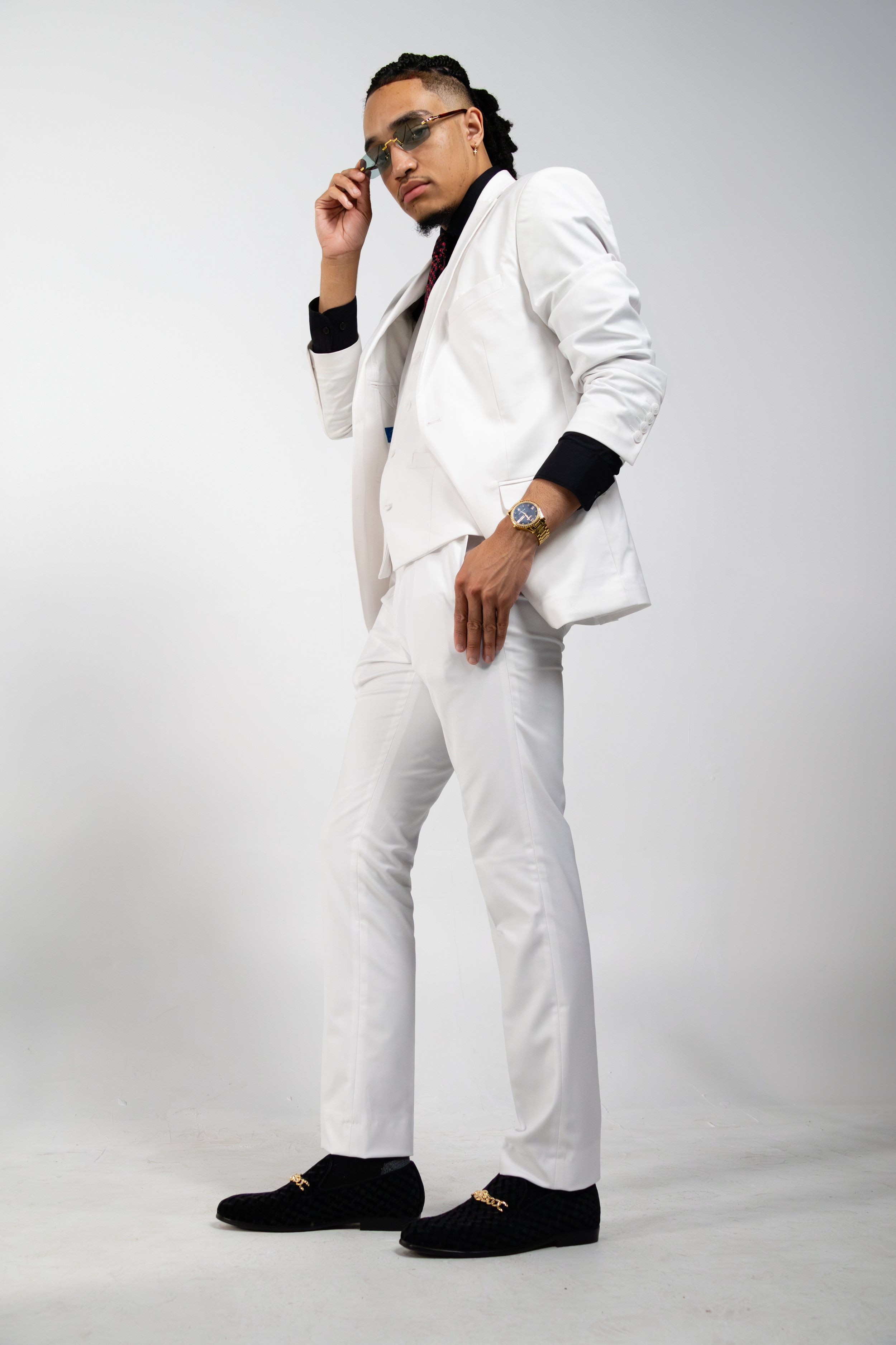 Man in white suit posing with sunglasses