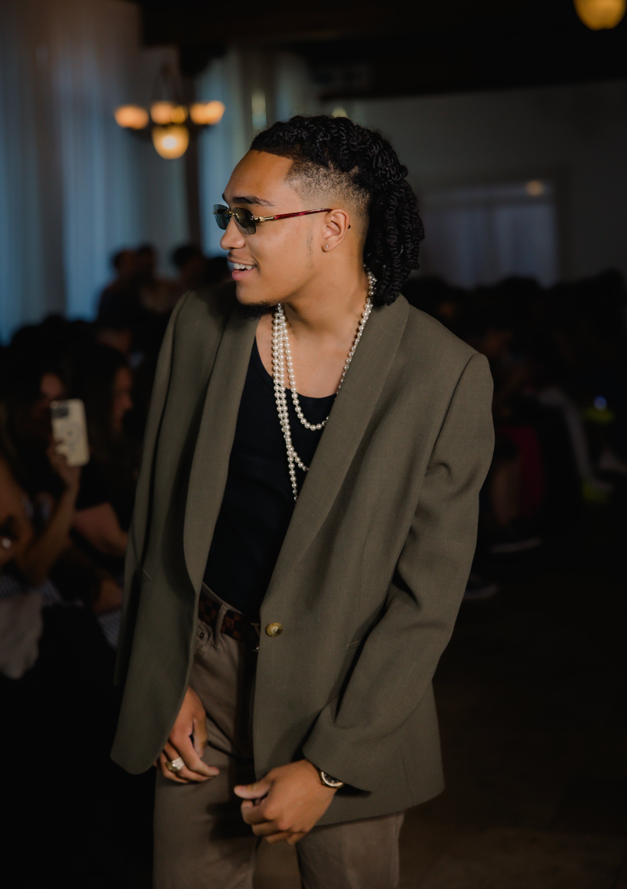 Man in a blazer and sunglasses at a fashion event