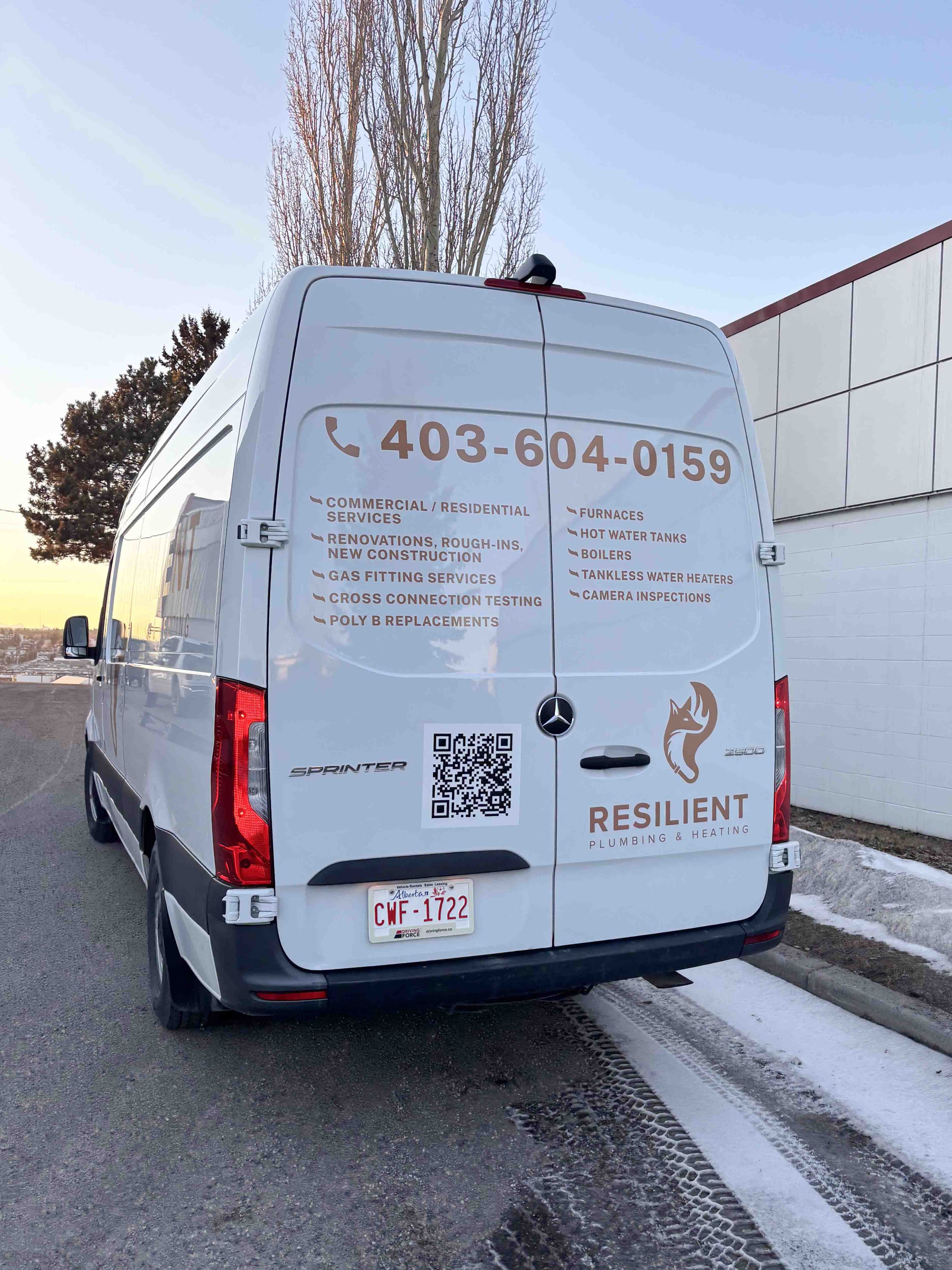 Rear view of a white Mercedes-Benz Sprinter van with contact information and services displayed on the back, including plumbing and heating services, with a QR code and a company logo reading 'Resilient Plumbing & Heating'. The van is parked on a str
