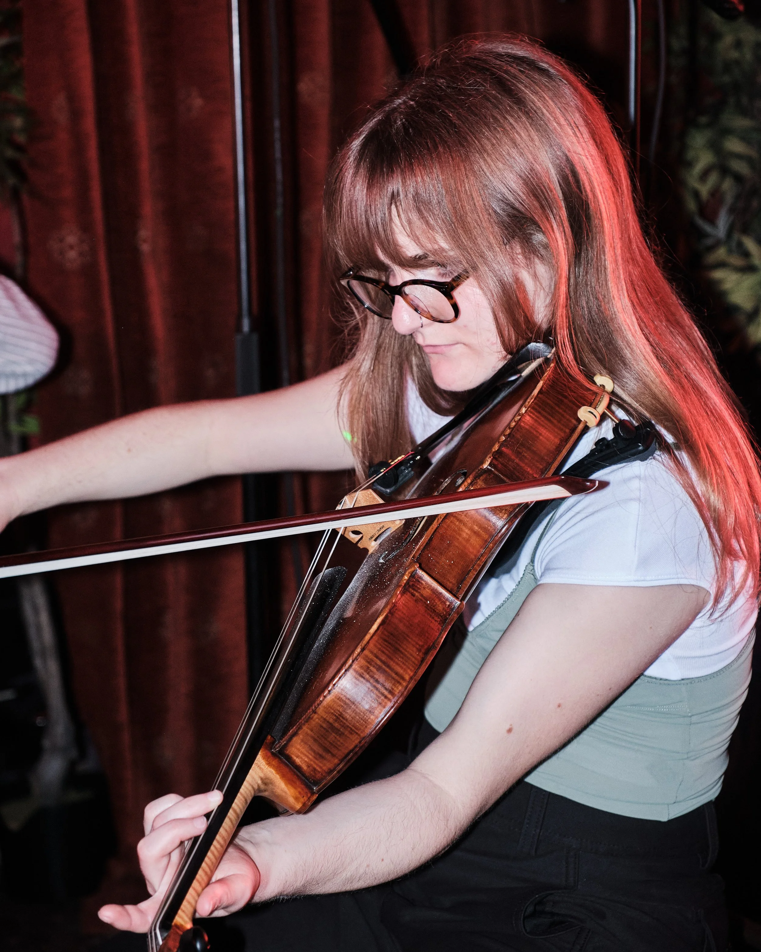 A young woman playing the viola during a musical performance.