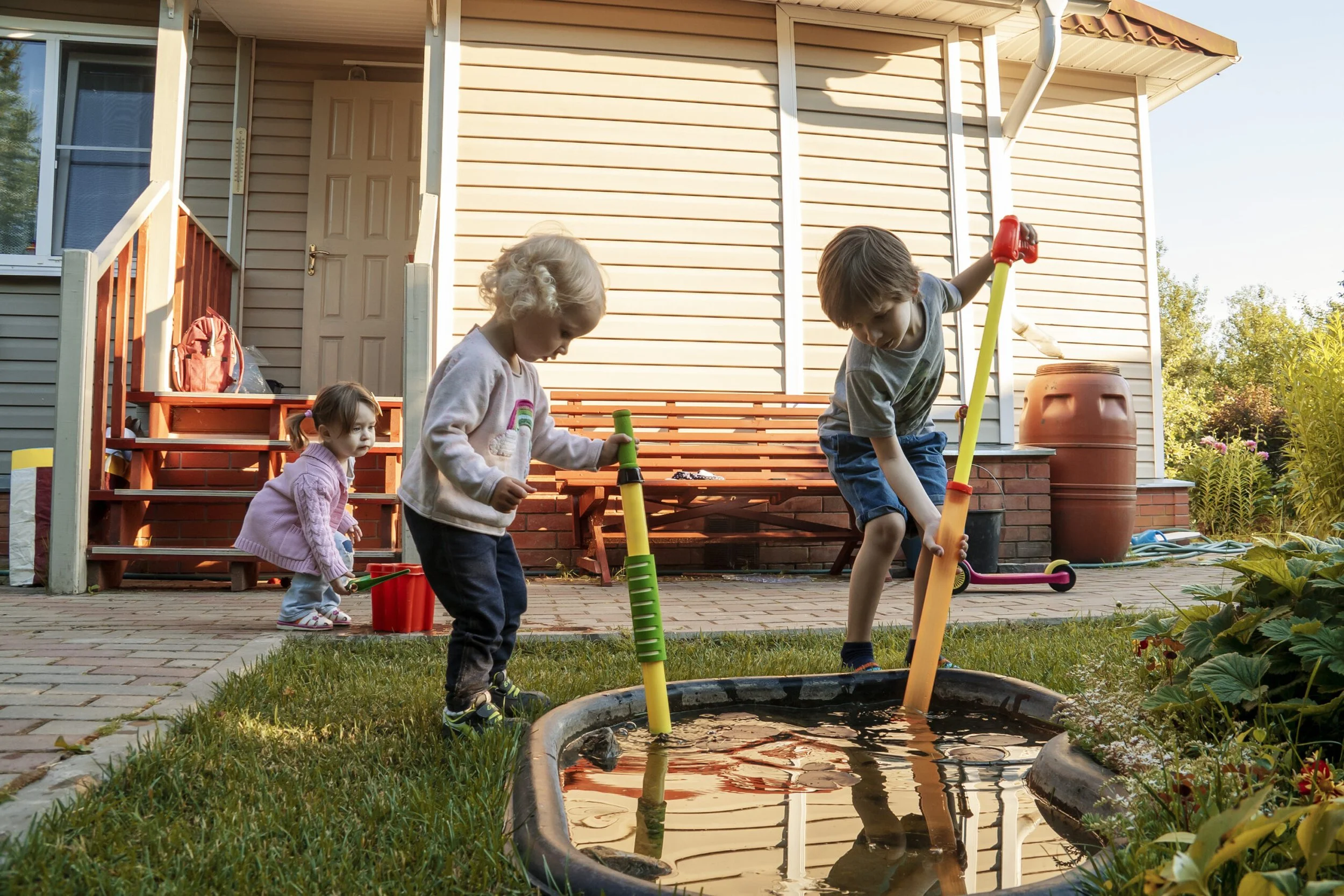 Children playing near standing water mosquito breeding area in Oklahoma City yard
