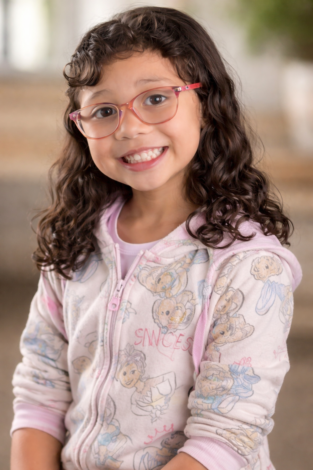 Arielle Jiang smiling child portrait wearing pink glasses and hoodie