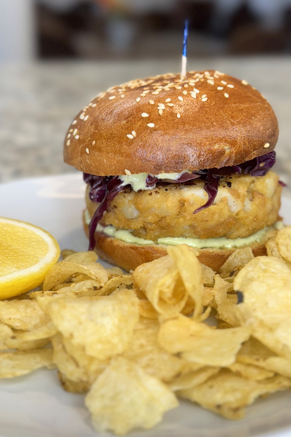 Lemony shrimp burger with sesame slaw and wasabi-ginger tartar sauce on a house-made bun and served with kettle chips
