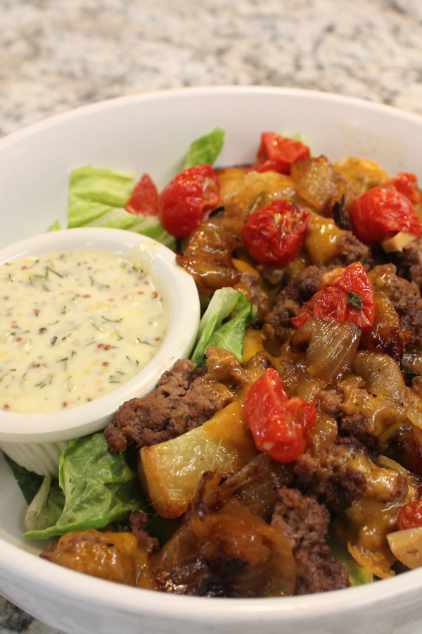 Ground beef with melted cheddar cheese, roasted potatoes, cider-glazed onions, and roasted cherry tomatoes served atop fresh greens with a ramekin of Nick’s burger sauce