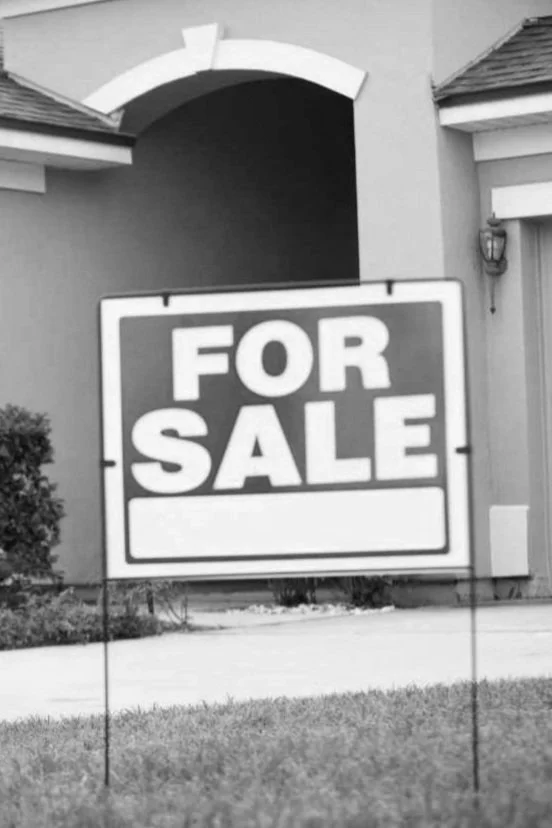 Panneau "à vendre" devant une maison.