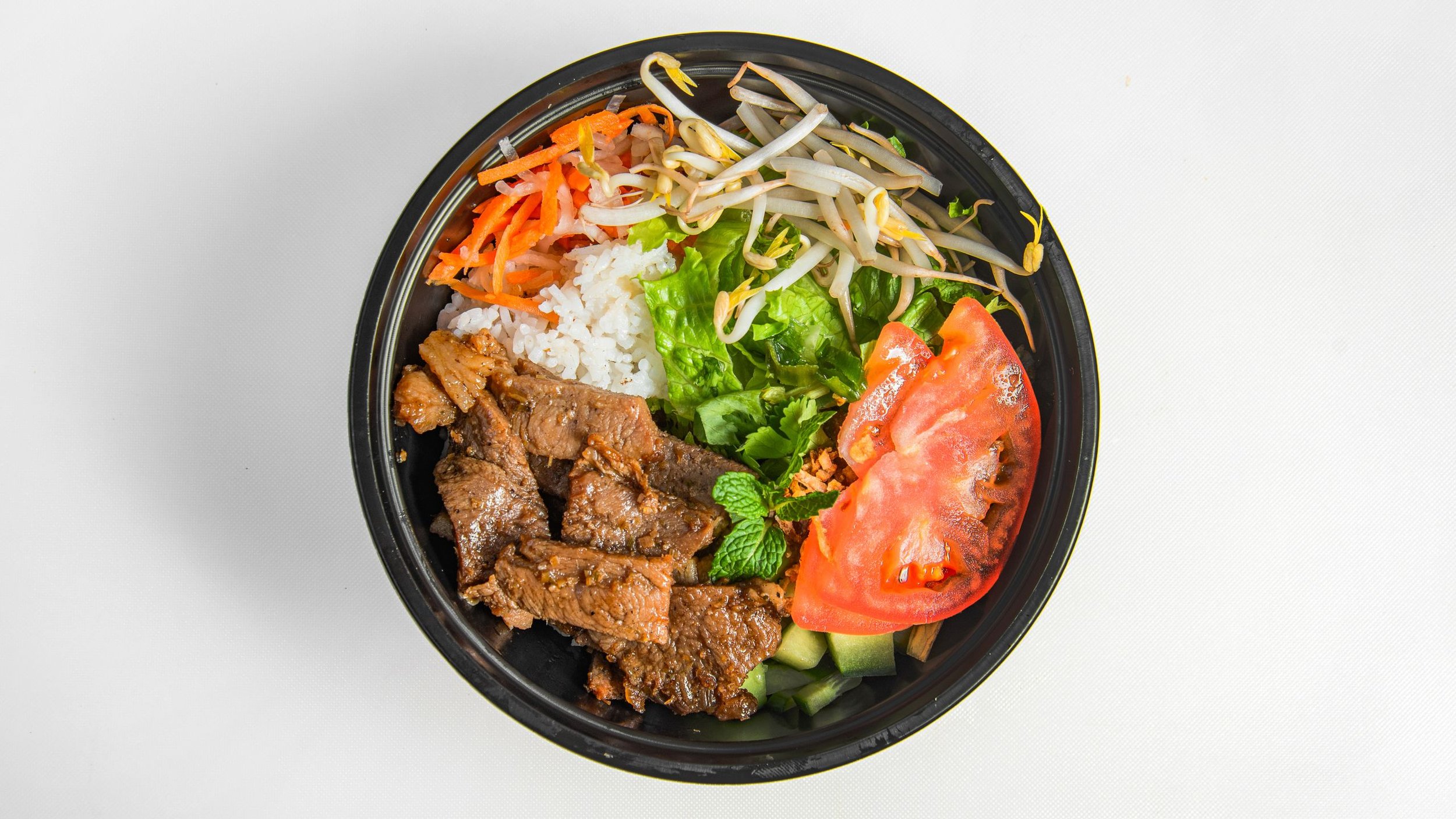 Vietnamese Jasmine Rice Bowl with fresh vegetables, pickled carrots and daikon, tomatoes, lettuce, crunchy bean sprouts, green onion oil, and fried onion