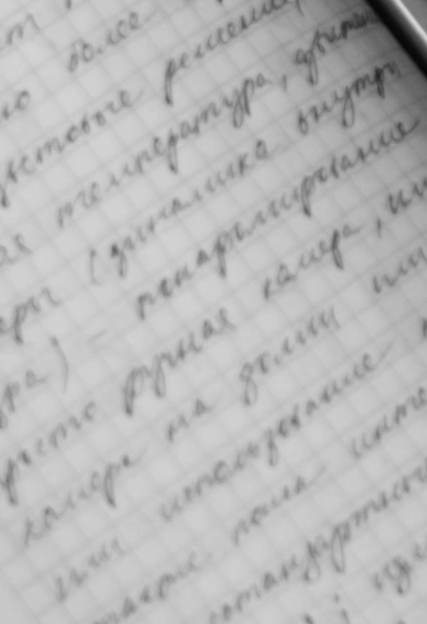 Close-up of a handwritten note on graph paper, with cursive writing that is slightly blurry and difficult to read.