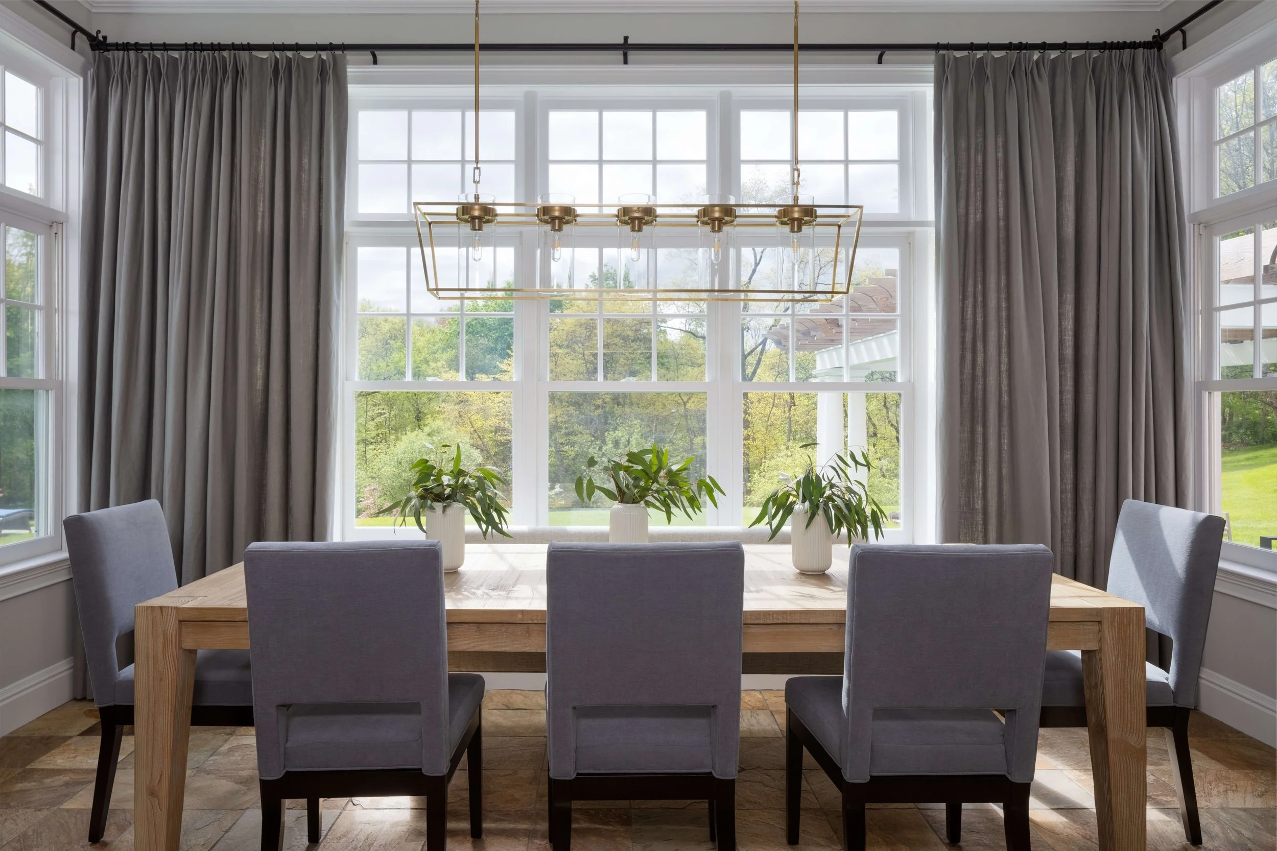 High end kitchen and interior design Fairfield County CT & Charlotte, NC: cozy living room vignette with accent chair, warm sunlight, and layered neutrals.