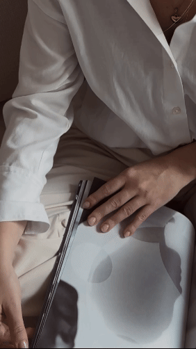 Person reviewing design selections and notes at a coffee table during an interior design planning session.