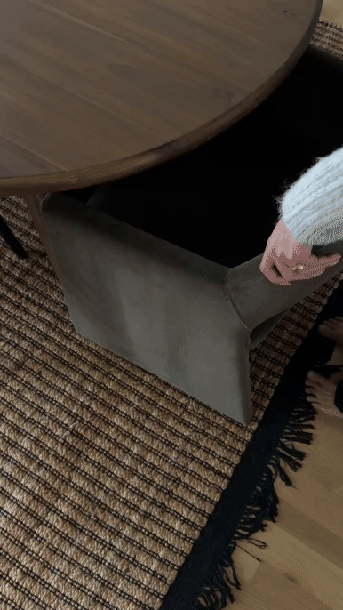Close-up of a chair beside a textured rug, styled in neutral tones for a calm, modern interior.