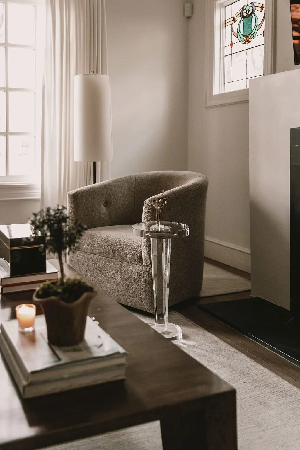High end kitchen and interior design Fairfield County CT & Charlotte, NC: cozy living room vignette with accent chair, warm sunlight, and layered neutrals.