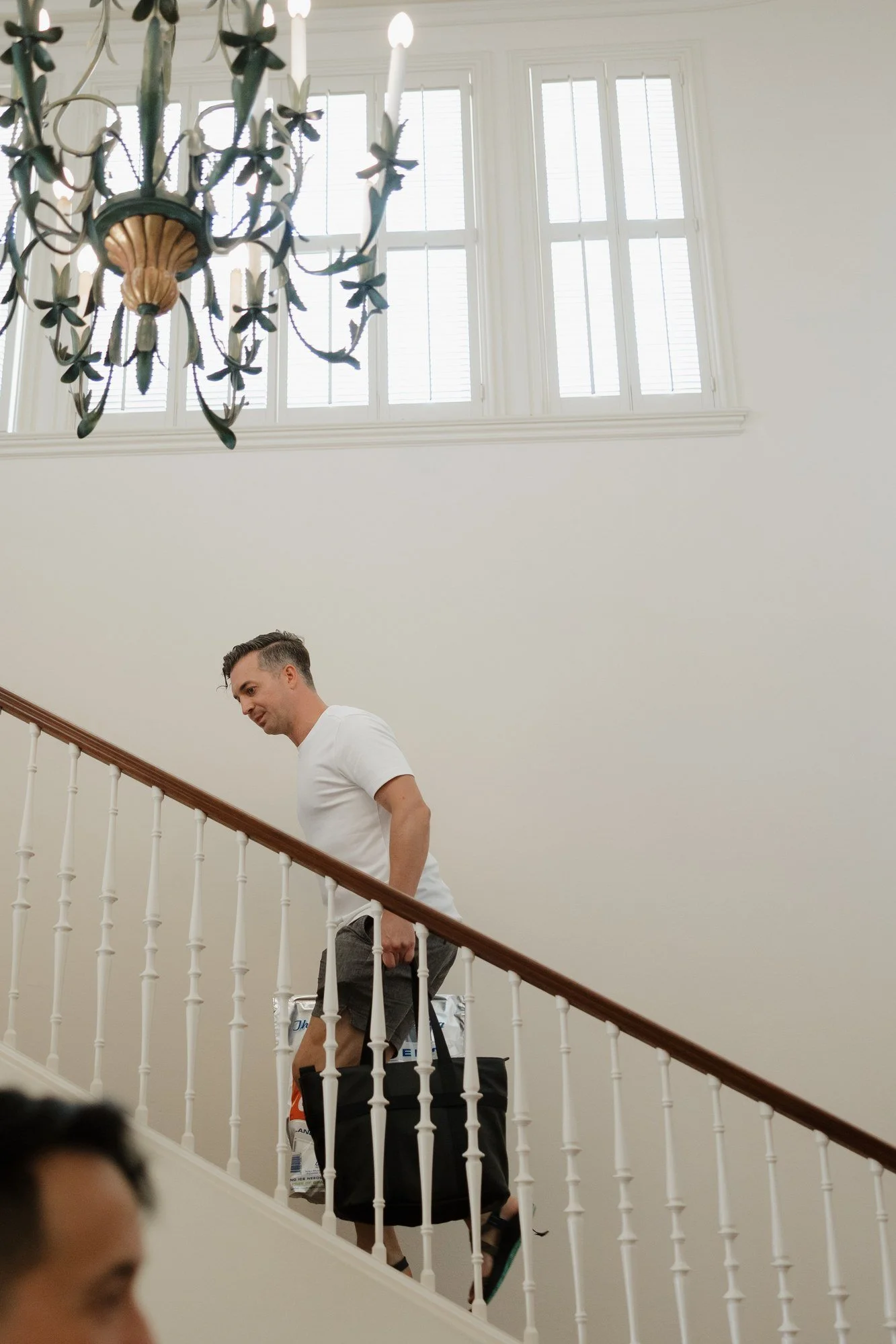 Member of the wedding party carrying bags up the staircase at Darlington House