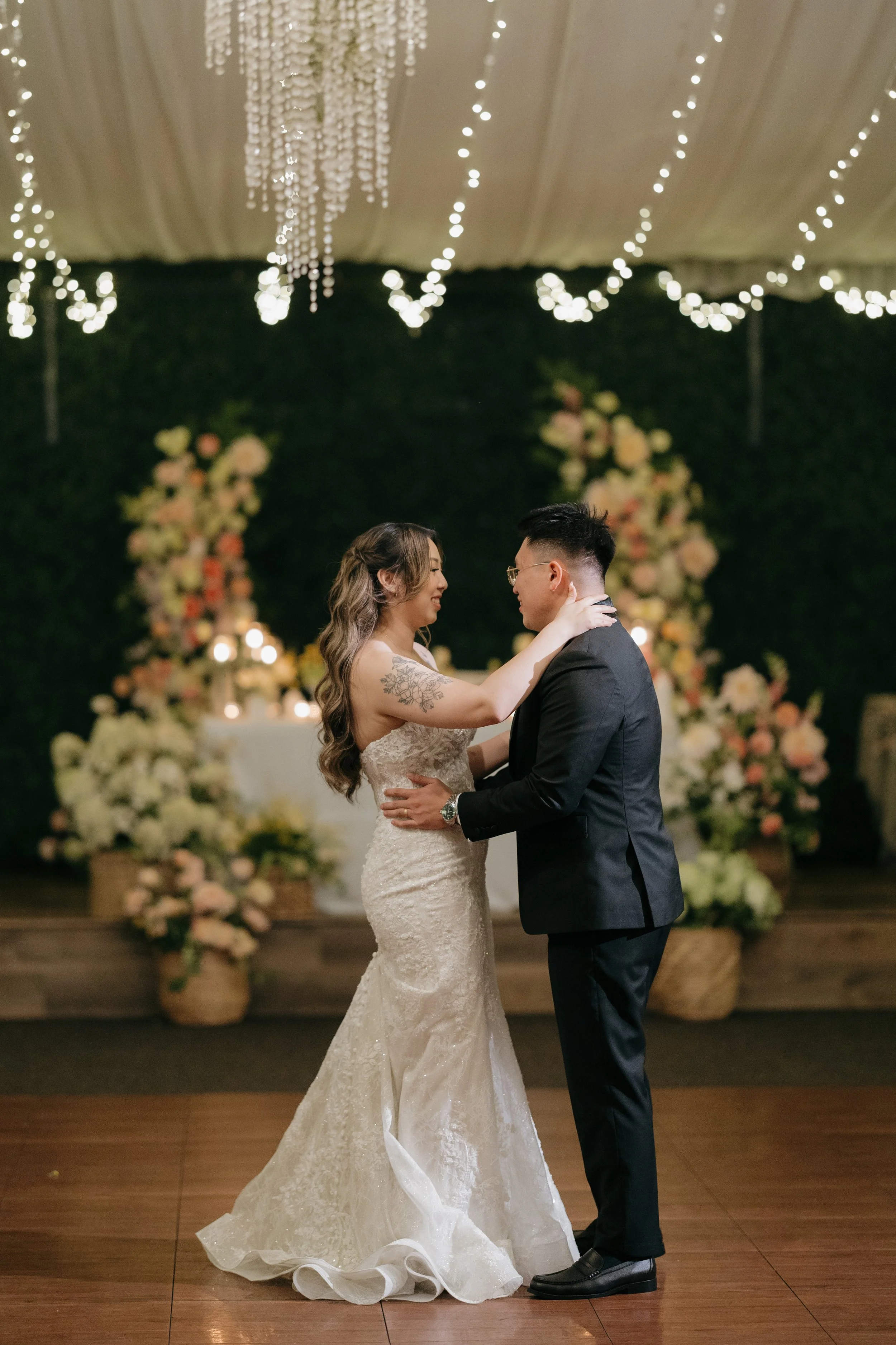 Nancy and Ken's first dance in front of a floral backdrop at their Green Gables reception