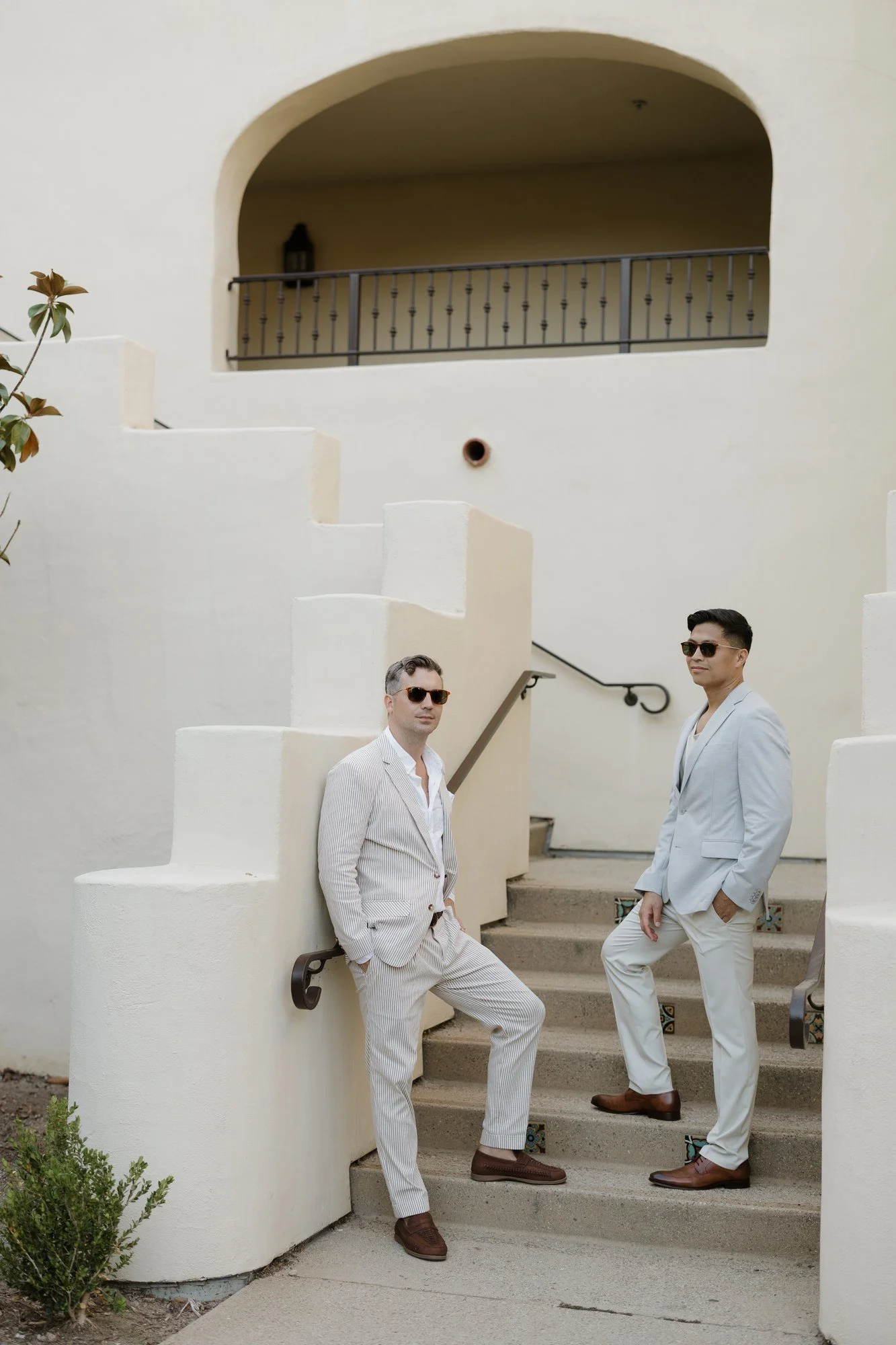 Ryan and Sean posing on a white arched stairway at Estancia La Jolla