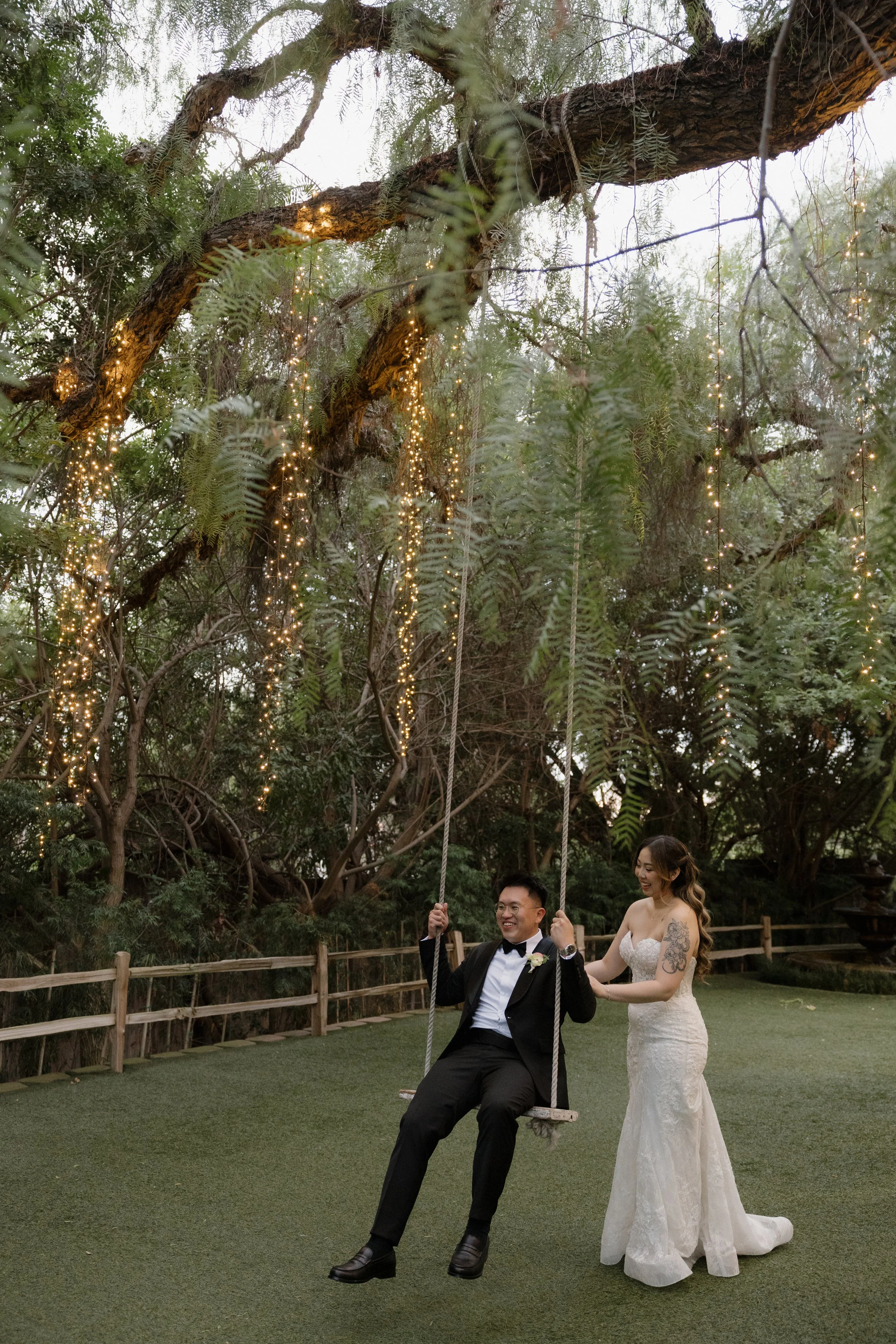 Ken on the tree swing with Nancy beside him at sunset at Green Gables Wedding Estate