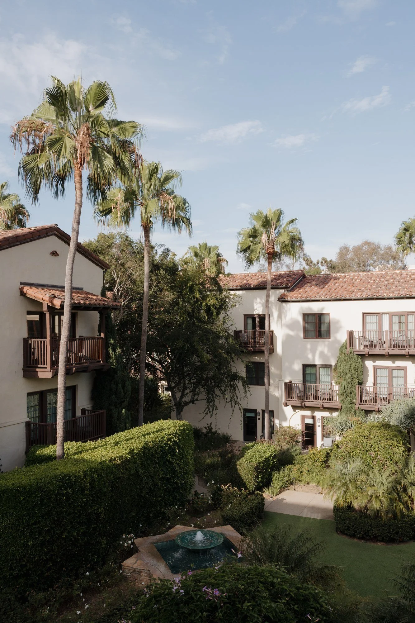 Estancia La Jolla Hotel and Spa hacienda gardens with palm trees and fountain