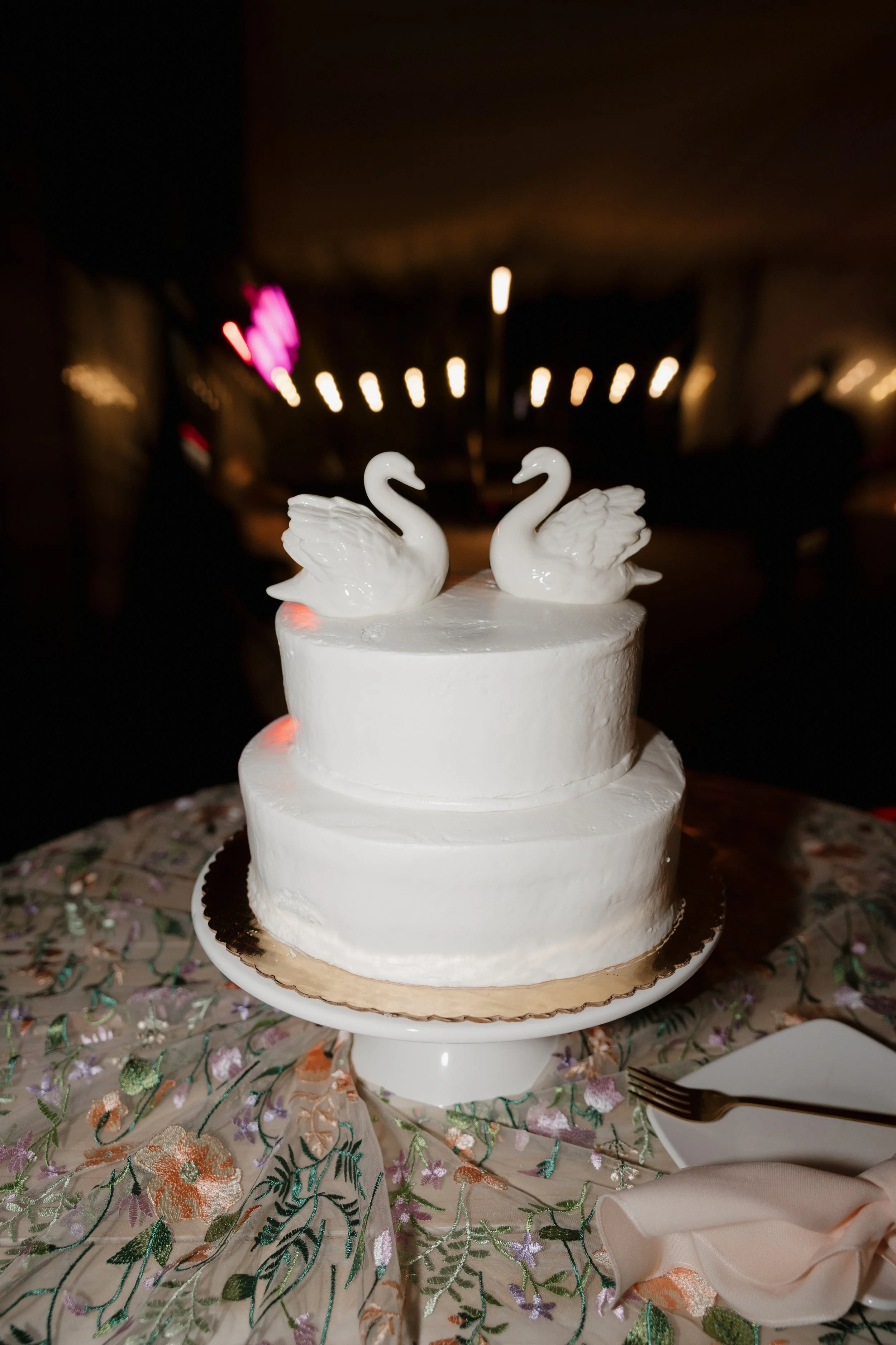 Two-tier white wedding cake topped with two swans at Green Gables Wedding Estate