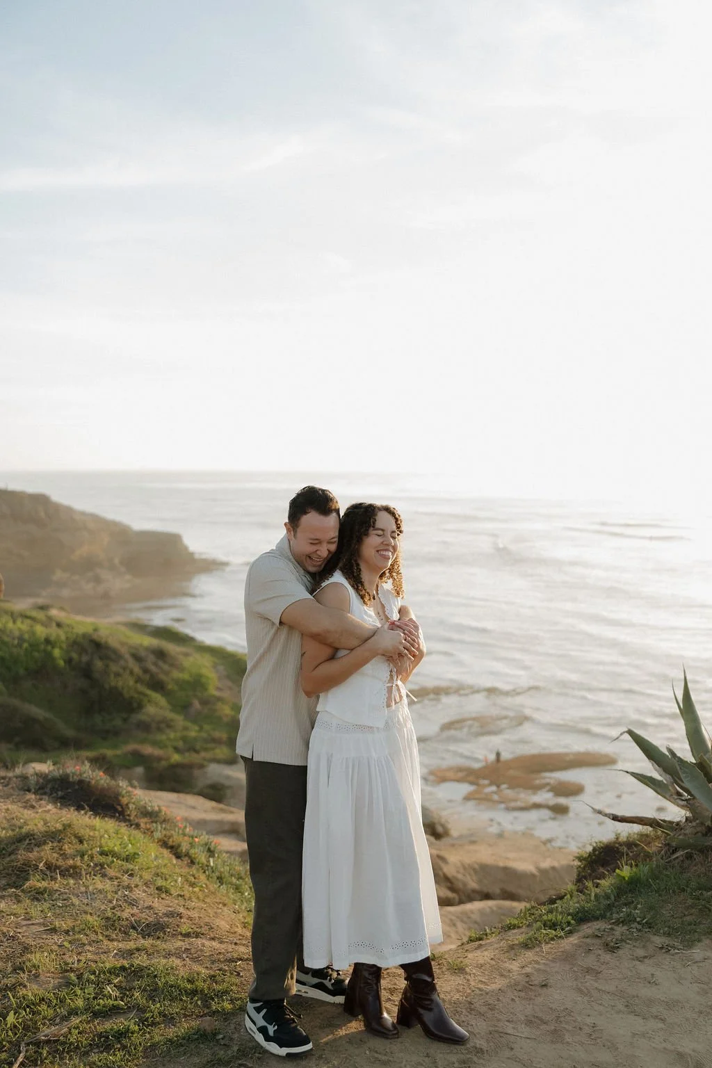 Couple embracing on the bluff above the Pacific at Sunset Cliffs
