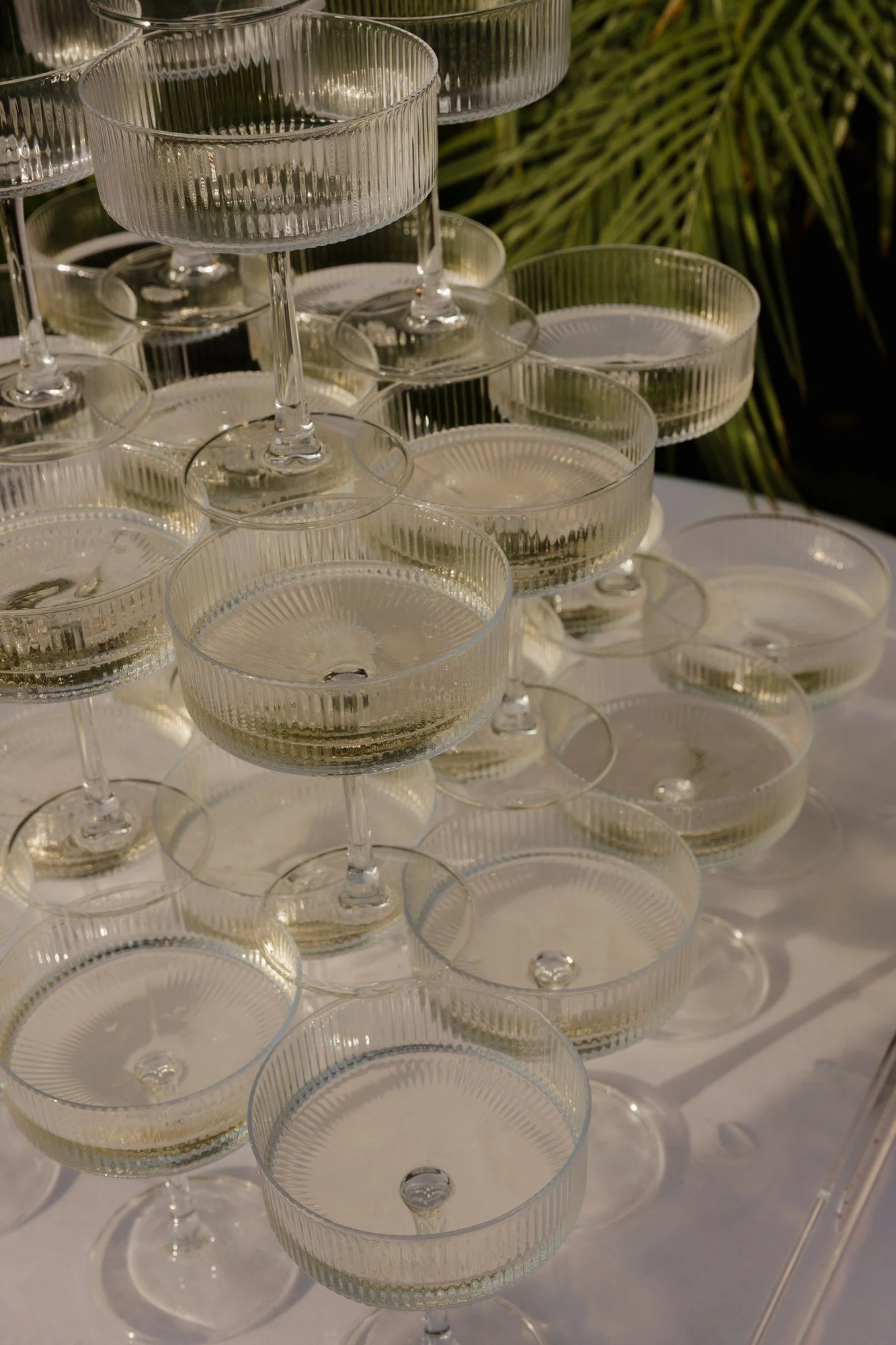 Close-up of ribbed champagne coupes stacked in a tower