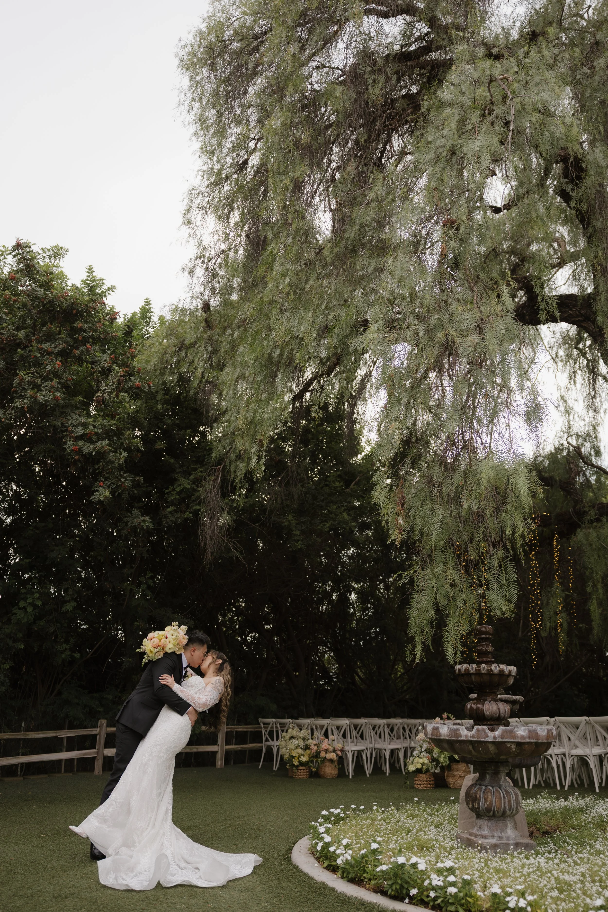 Ken dipping Nancy for a kiss under a willow tree near the Green Gables fountain