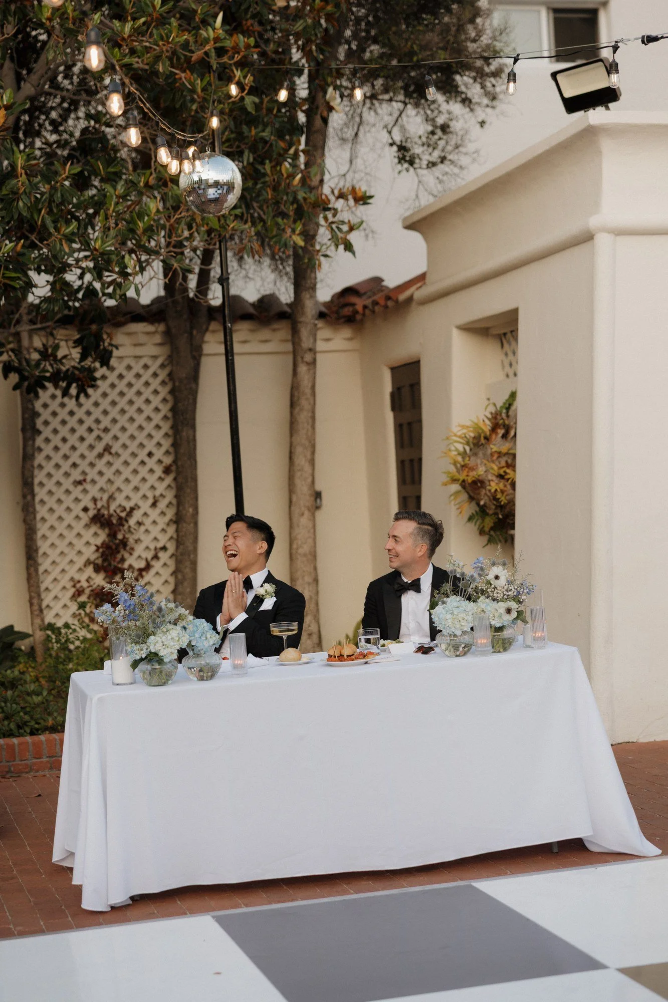 Ryan and Sean laughing at their sweetheart table during toasts at Darlington House