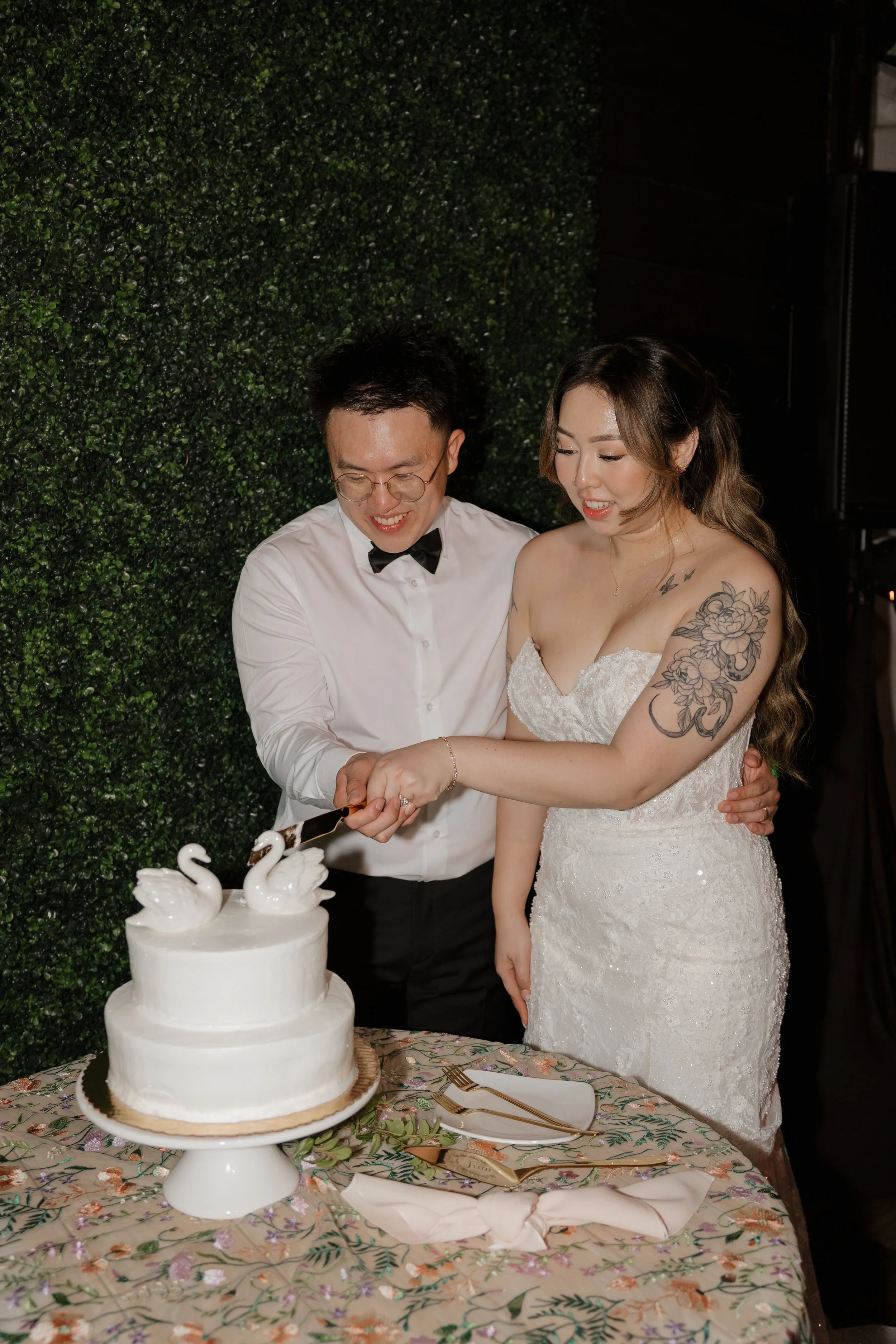 Nancy and Ken cutting their swan-topped wedding cake at their Green Gables reception