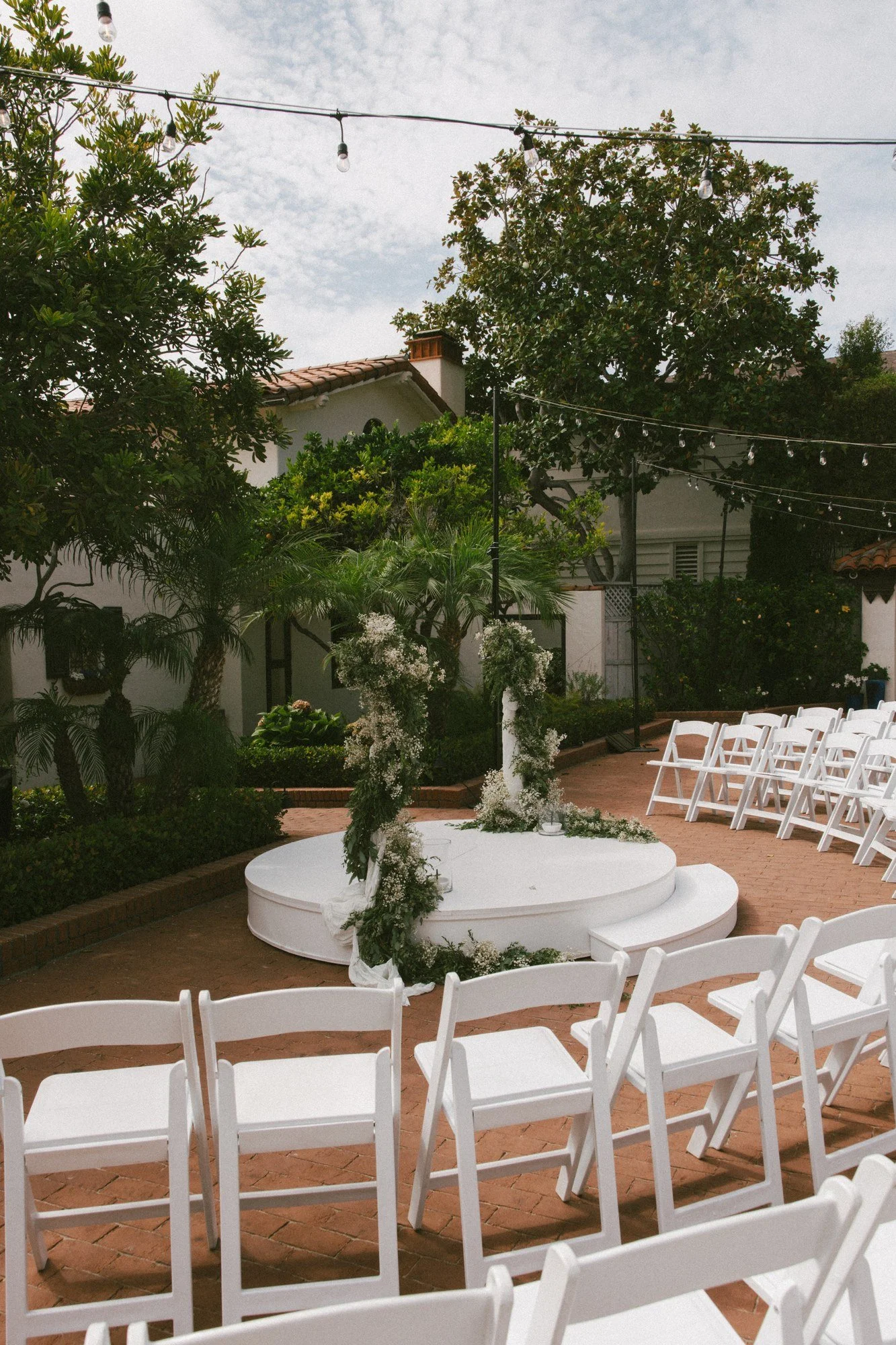 Ceremony setup at Darlington House with a round greenery-wrapped stage and chairs in the round