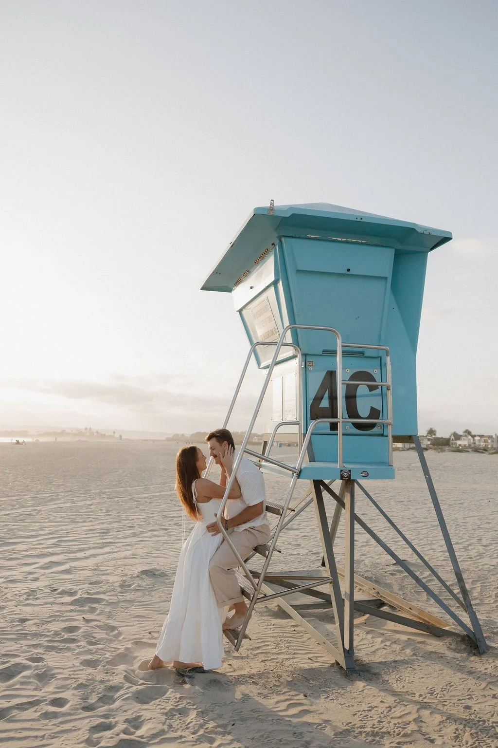 Couple beside a blue lifeguard tower on Coronado Beach