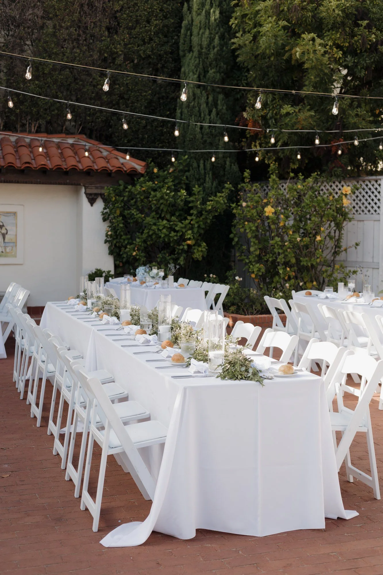 Long reception tables under string lights in the Rose Garden at Darlington House