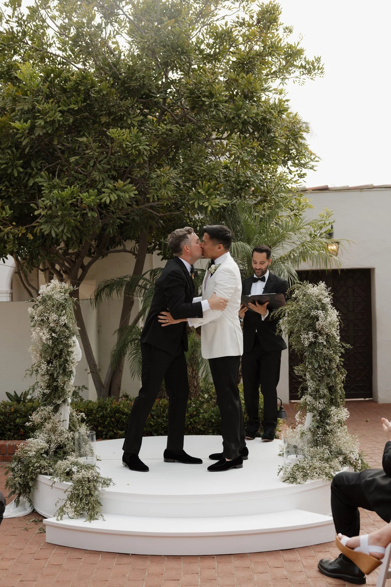 Ryan and Sean's first kiss as a married couple on the greenery-wrapped stage at Darlington House