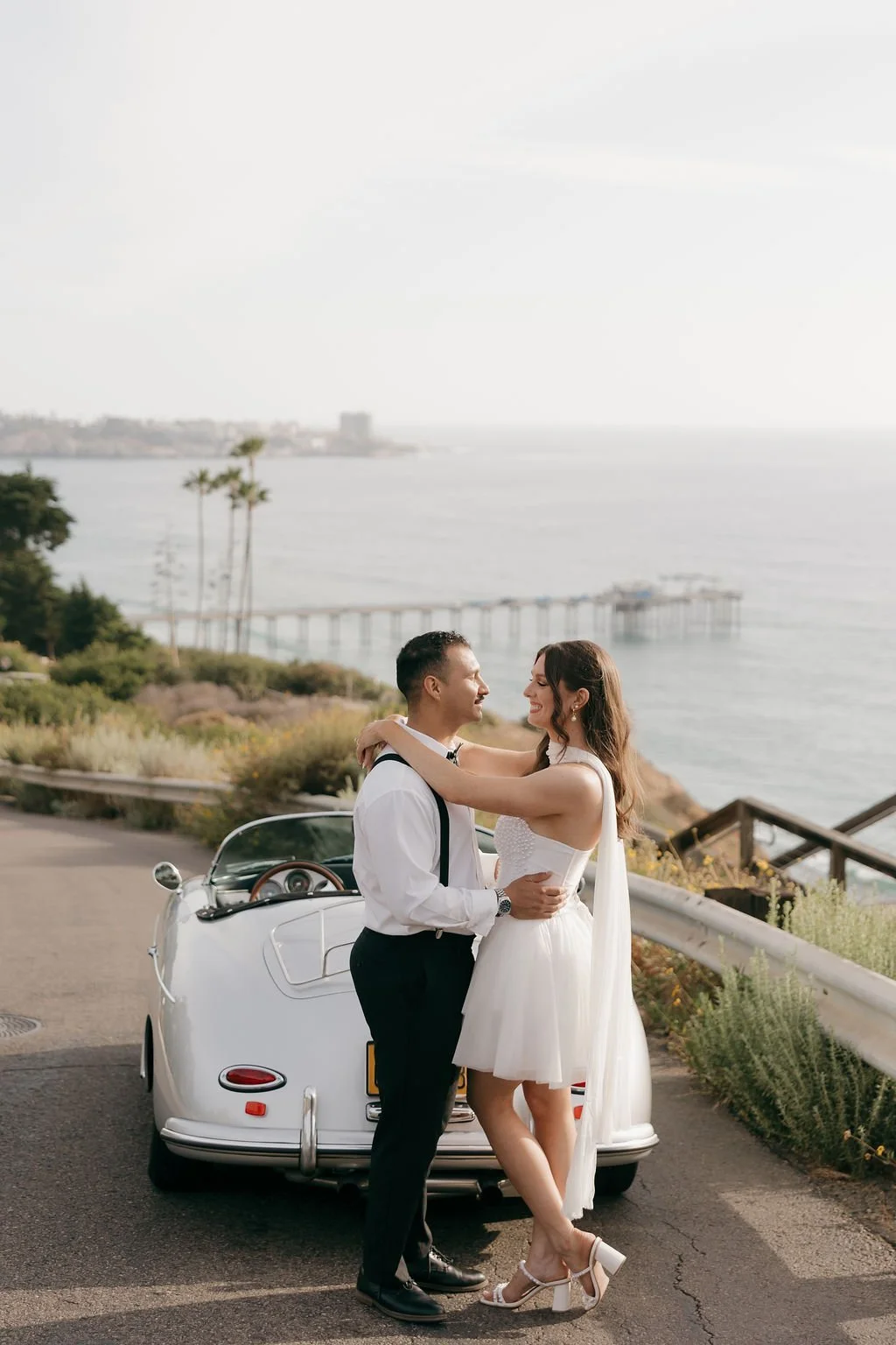 Couple with a vintage convertible overlooking Scripps Pier
