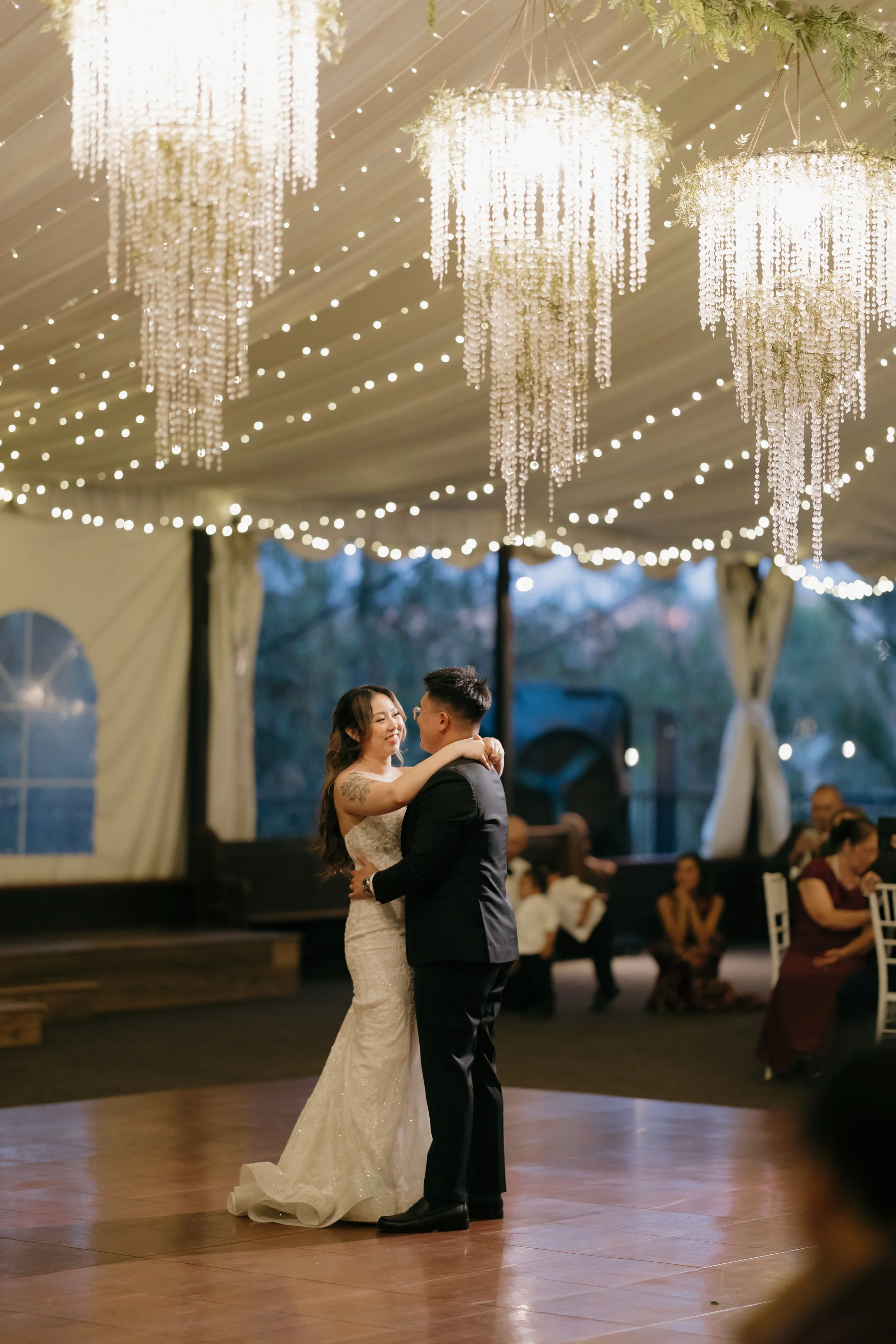 Nancy and Ken dancing beneath crystal chandeliers in the Green Gables reception tent