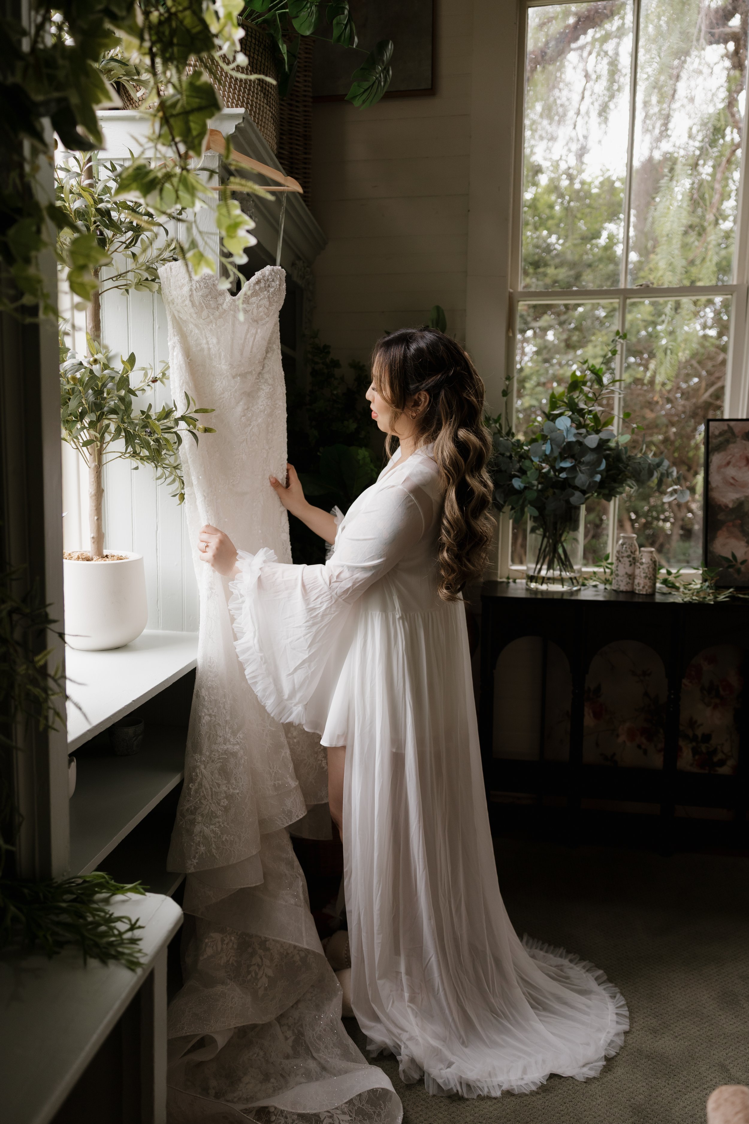 Nancy looking at her wedding gown by the window of the Green Gables Bridal Salon