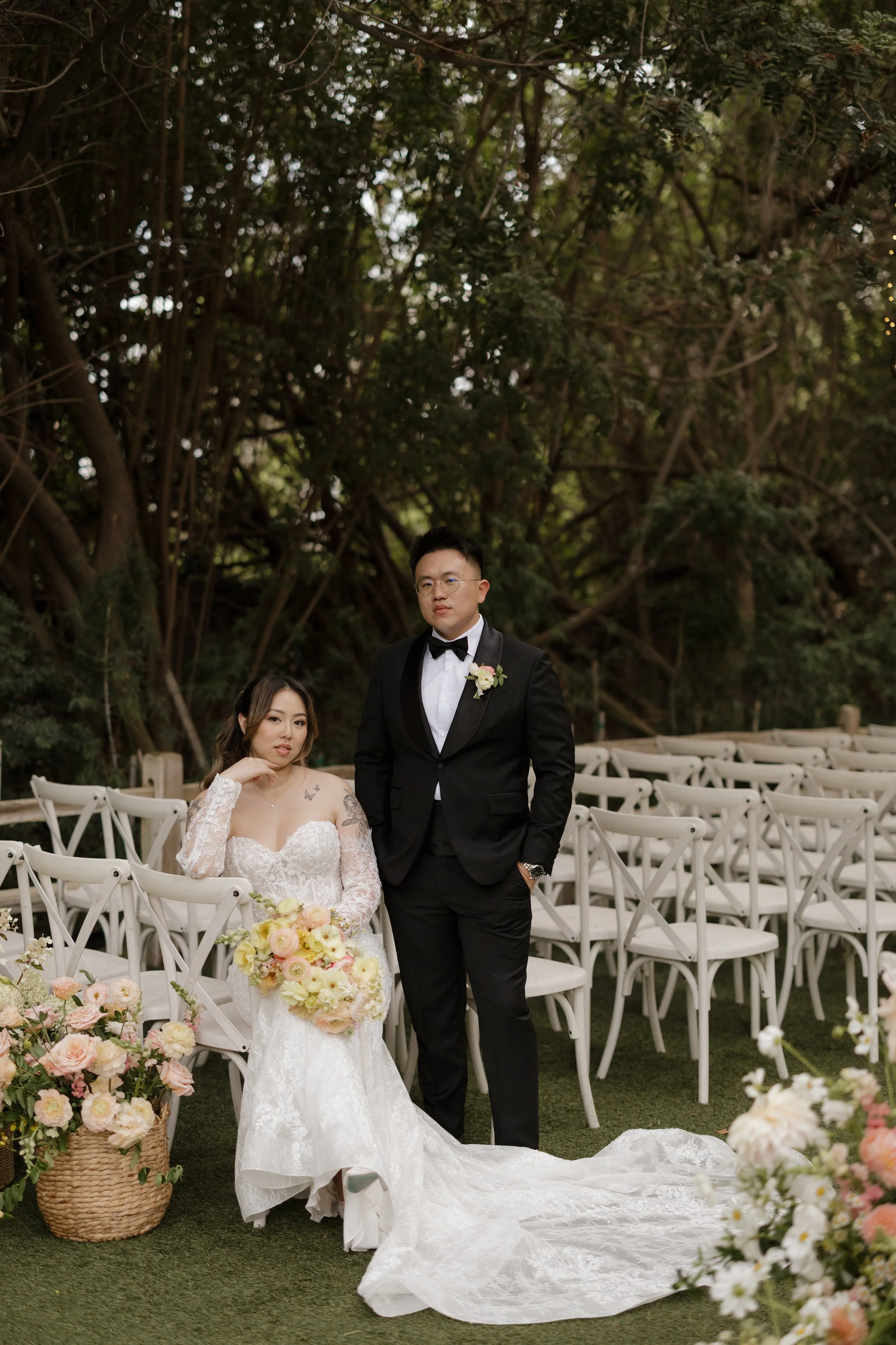 Nancy and Ken posing beside the white ceremony chairs before their San Marcos wedding