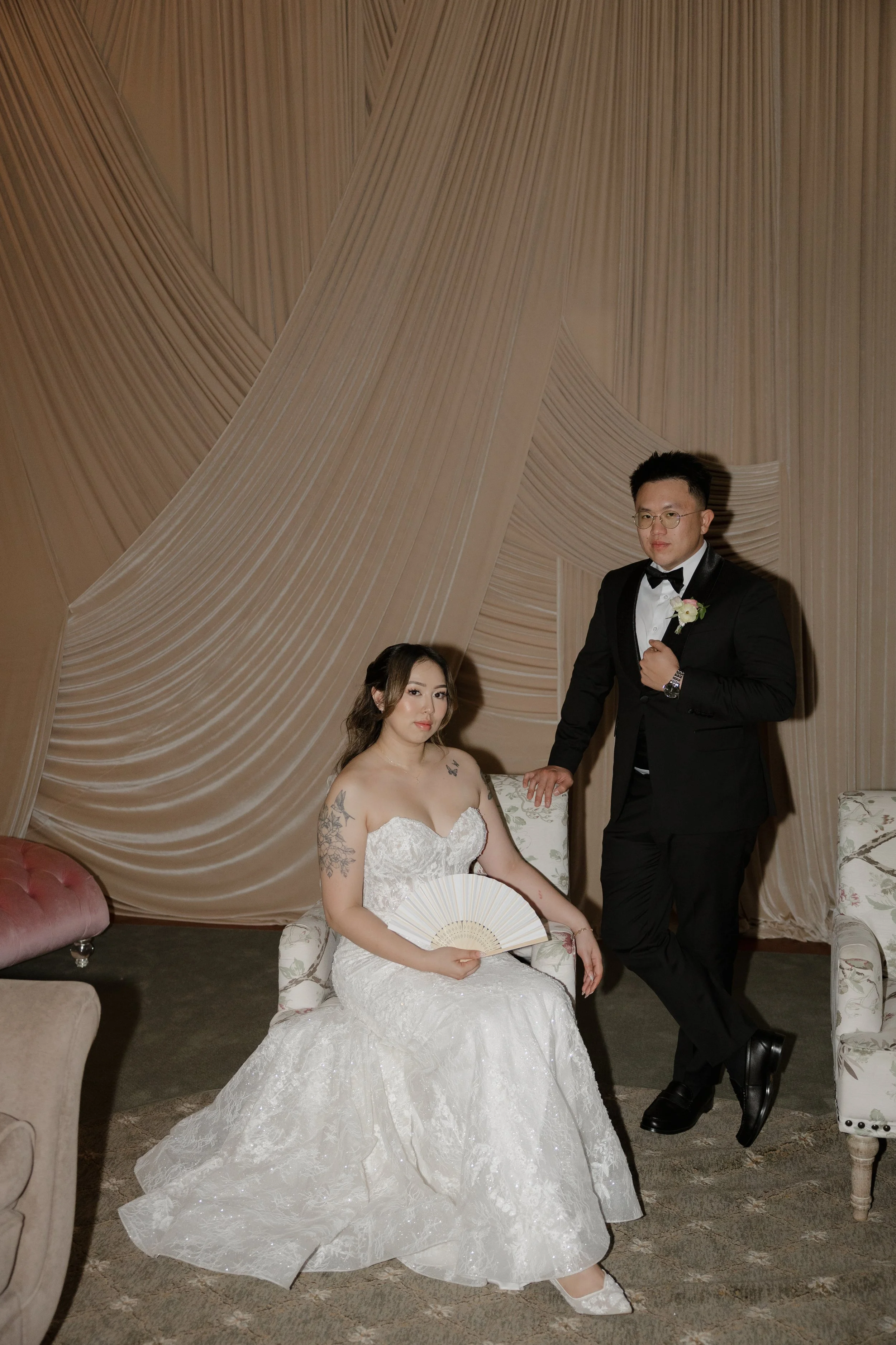 Nancy and Ken in an evening portrait among the draped fabric of the Green Gables Bridal Salon